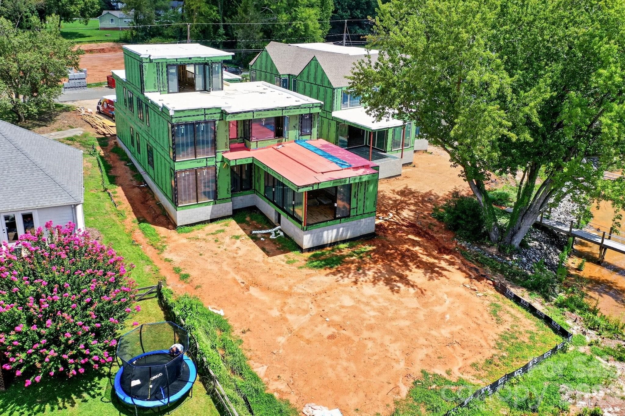 Real life construction process showing the home is under roof with windows and roofing completed in 8/2026. Has a fantastic backyard for a pool! - Cornelius