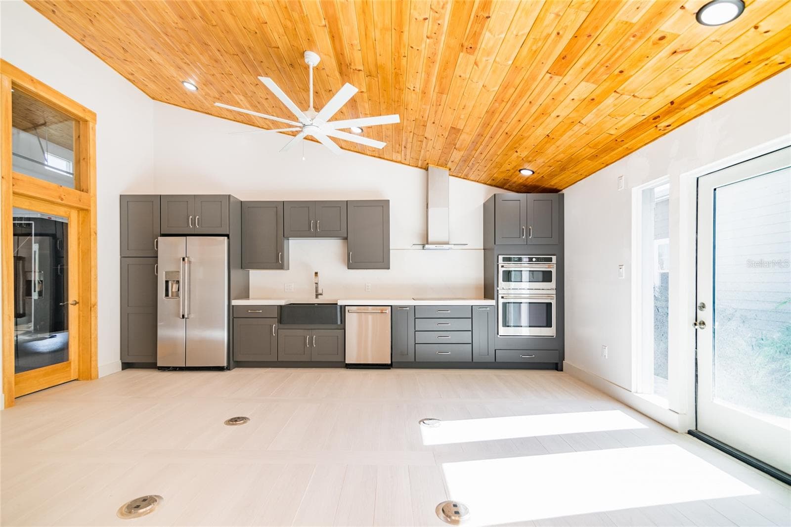 Kitchen and open space - showing without the existing furnishings. Door on right leads to the hot tub. - 6757 AMANDA VISTA CIR, LAND O LAKES
