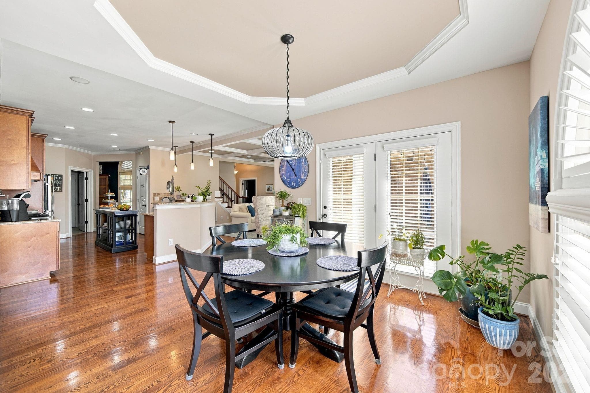 Bright eat-in area with a tray ceiling, hardwood floors, and easy access to the backyard, all open to the kitchen and living spaces. - 1001 Heritage Acres Drive, Weddington