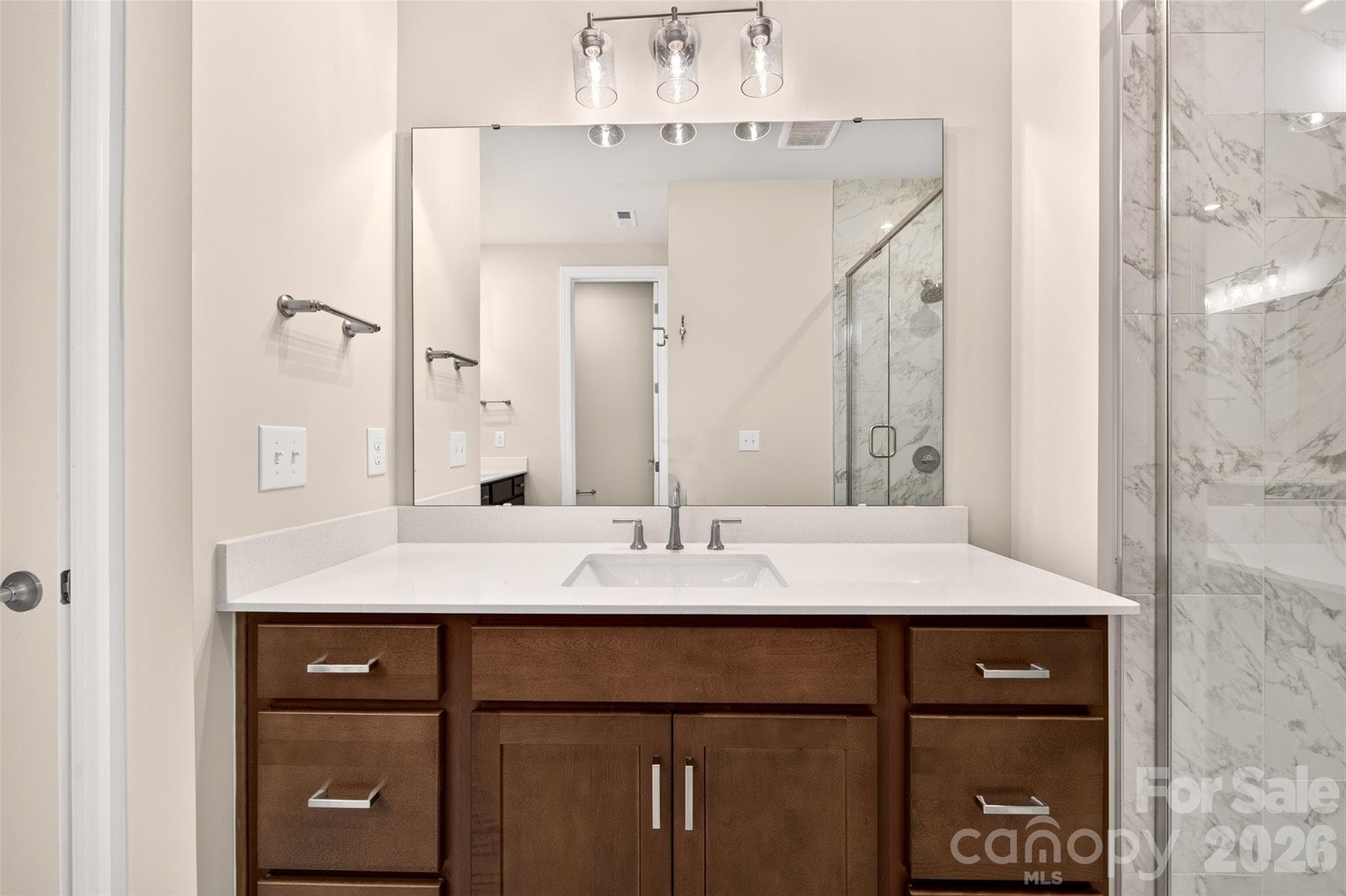 Rich brown cabinets paired with white quartz countertops - 6008 Yellow Buckeye Drive, Charlotte