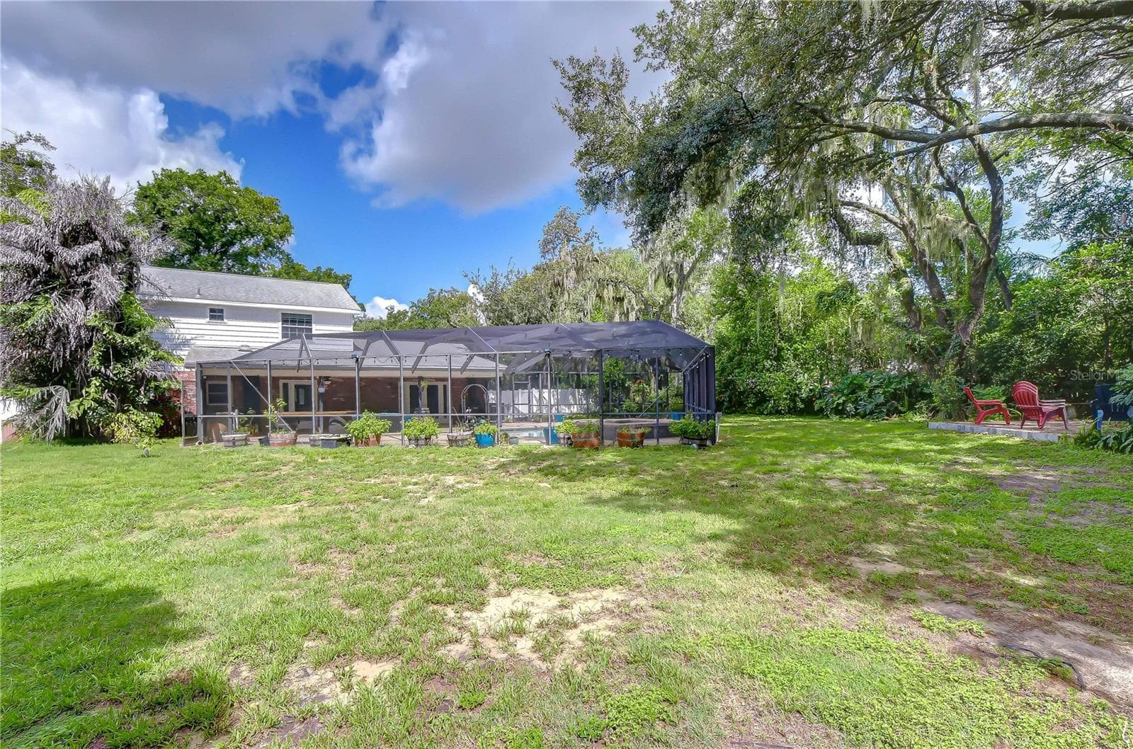 Expansive lawn extends beyond the screened enclosure with abundant room for recreation - 901 WOODVIEW DR, BRANDON