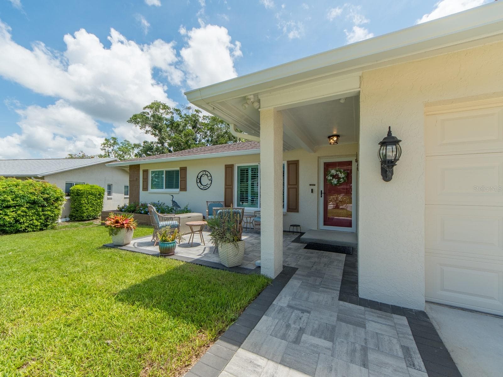 Manicured landscaping with pavers leading to the covered front entry. - 1207 TIMBERBROOKE DR, PALM HARBOR