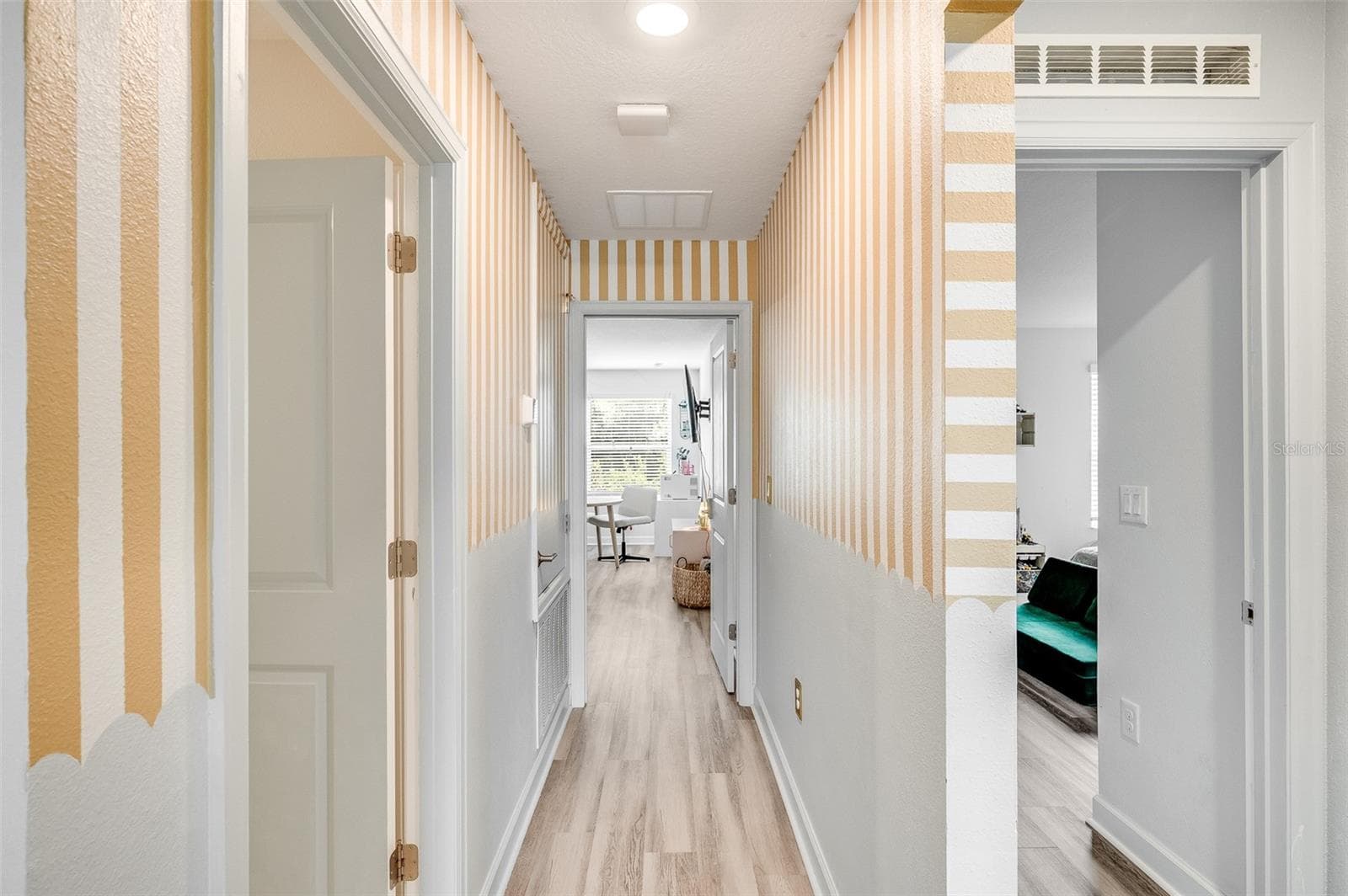 Hallway view of bedroom 3 to the right, upstairs primary straight ahead, and laundry room to the left - 2353 CRESCENT MOON ST, KISSIMMEE