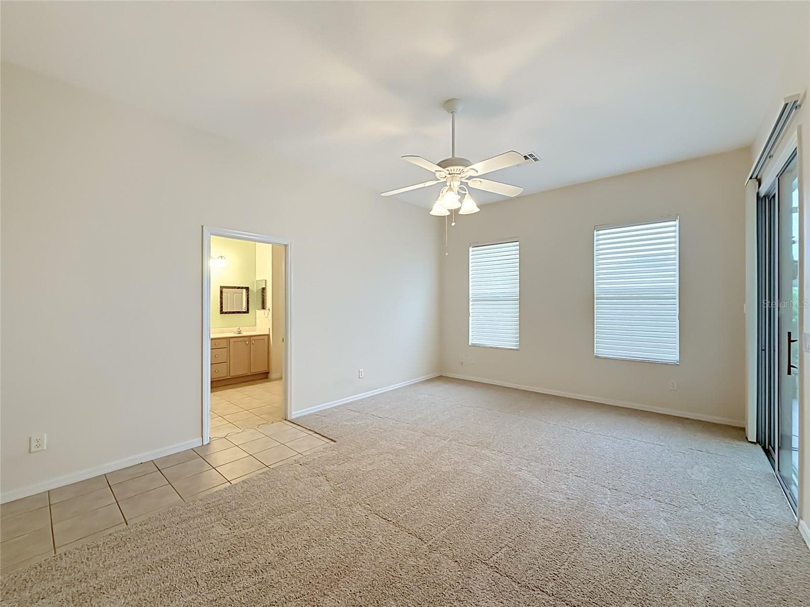 Primary ensuite with slider to The Florida room. - 11932 SE 179TH ST, SUMMERFIELD