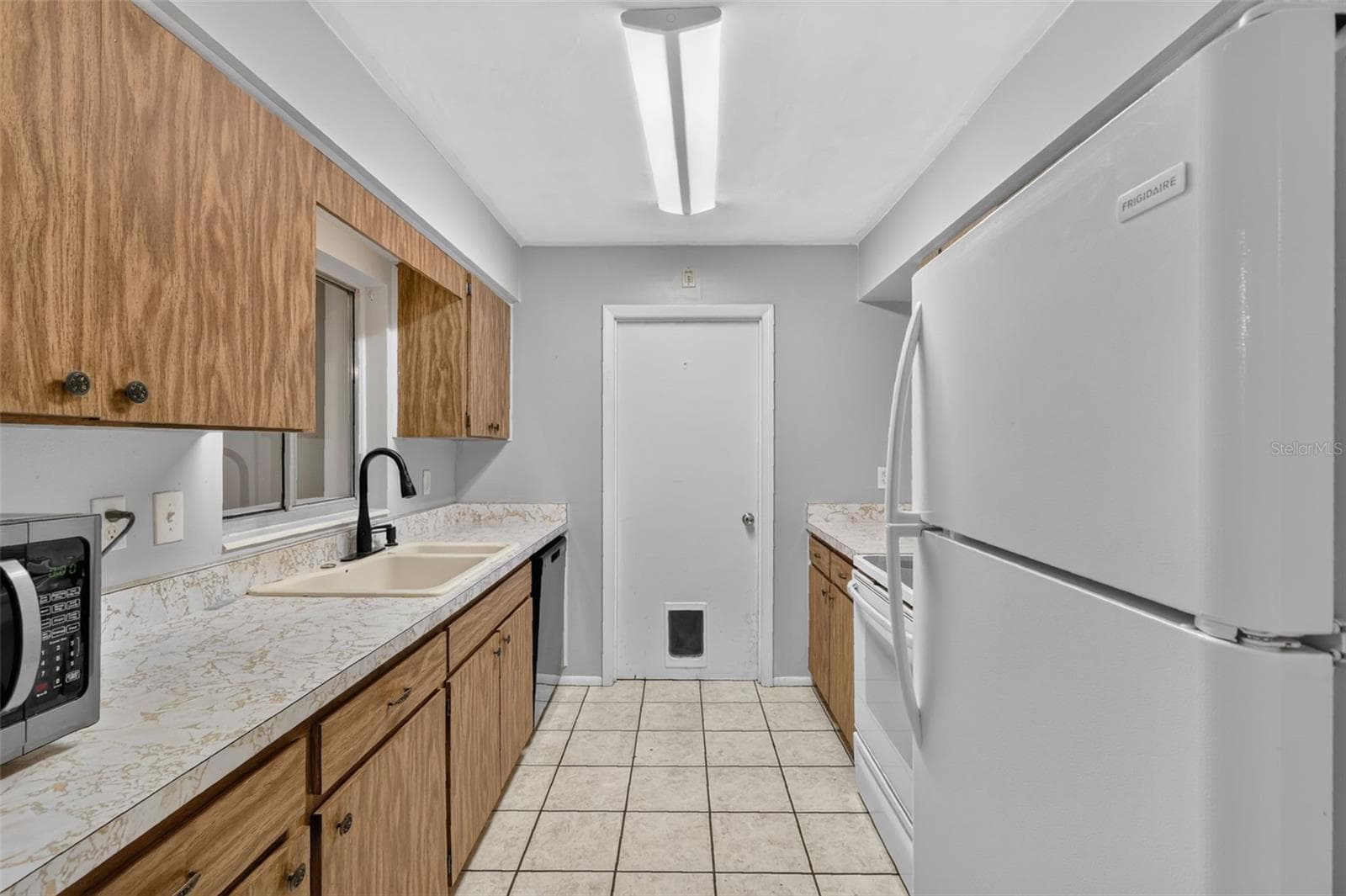 Galley-style Kitchen with Ample Cabinet and Counter Space - 1305 ORANGE AVE, TAVARES