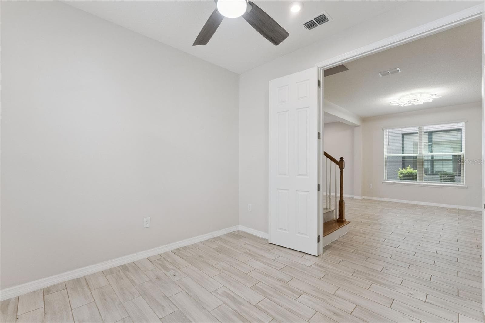 Downstairs Study – Bright, versatile main-level study with neutral finishes, tile flooring, a ceiling fan, and natural light, offering flexible space for a home office, reading room, or creative workspace. - 1287 VERDANT GLADE PL, WINTER PARK