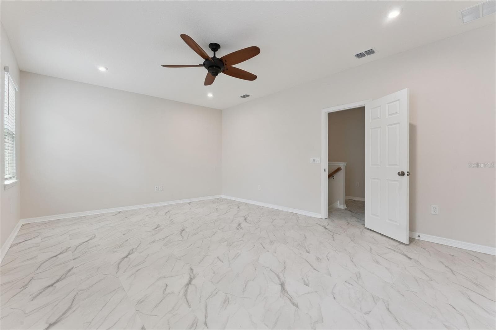 Bonus Room – Spacious enclosed upstairs bonus room with marble-look tile flooring, recessed lighting, and a ceiling fan, offering flexible space for a media room, game room, or home office. - 1287 VERDANT GLADE PL, WINTER PARK