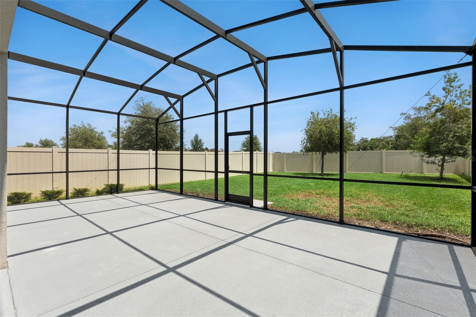 Screened Patio – Another view of the screened patio showcases its open layout and convenient access to the grassy backyard. - 1287 VERDANT GLADE PL, WINTER PARK