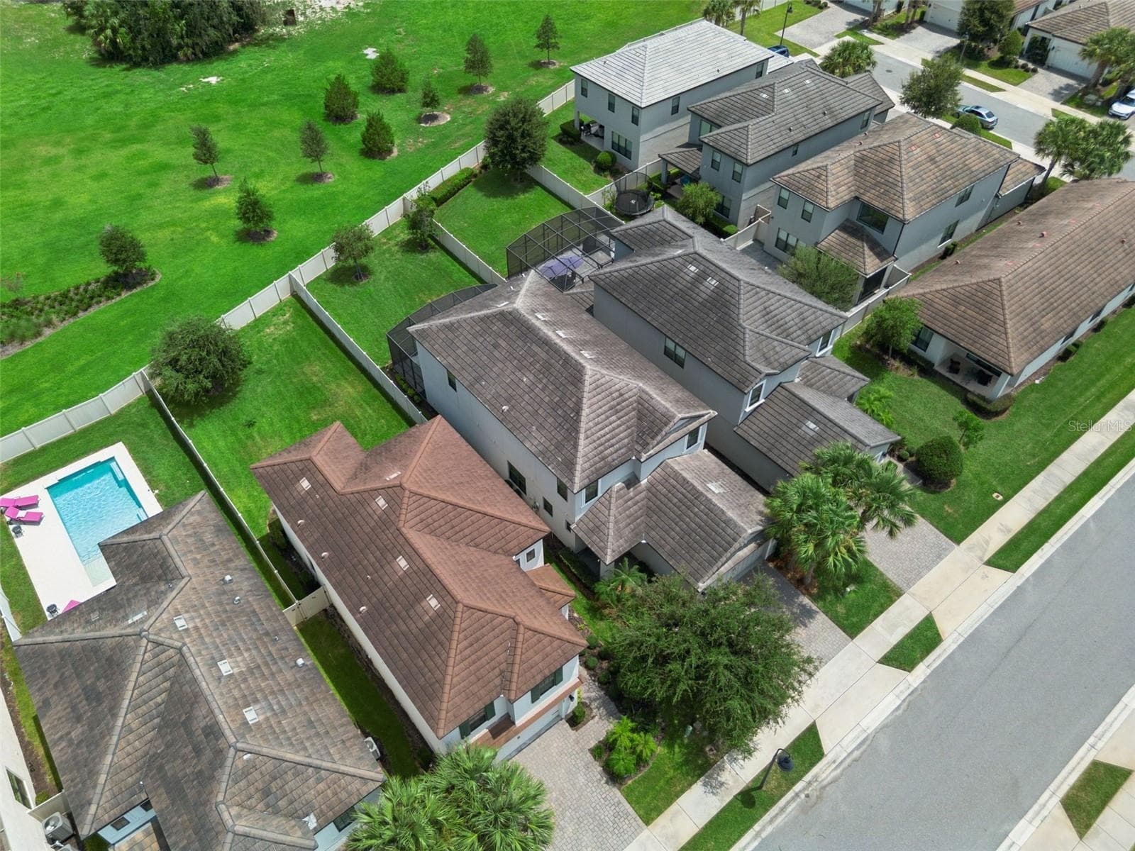 Overhead perspective highlights the home's two-story footprint, screened patio, fenced yard, and relationship to the surrounding green space. - 1287 VERDANT GLADE PL, WINTER PARK