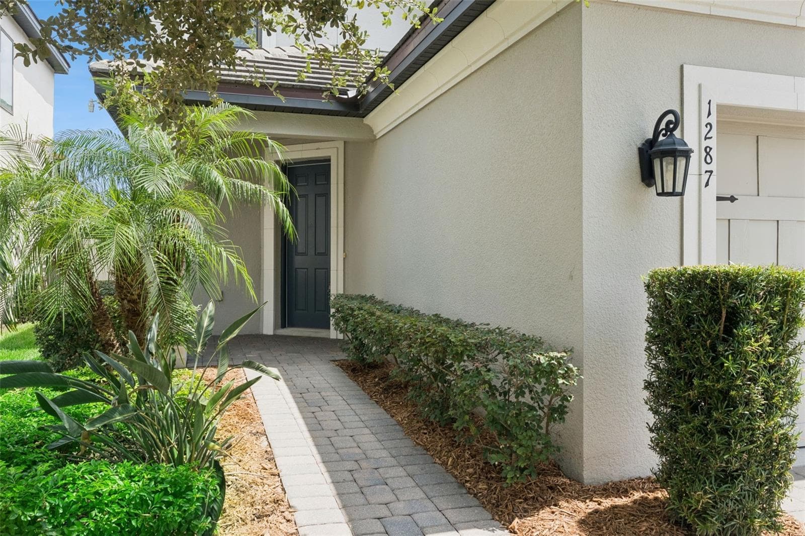 Front Entry – A landscaped paver walkway leads to the covered front entry, creating an inviting approach to the home. - 1287 VERDANT GLADE PL, WINTER PARK