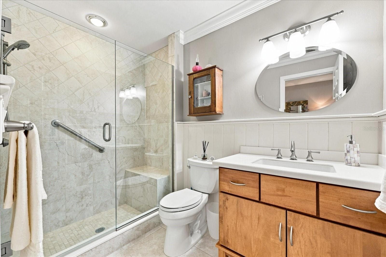 Primary Shower with built-in bench seating and another vanity with storage. - 3252 RINGWOOD MDW #81, SARASOTA
