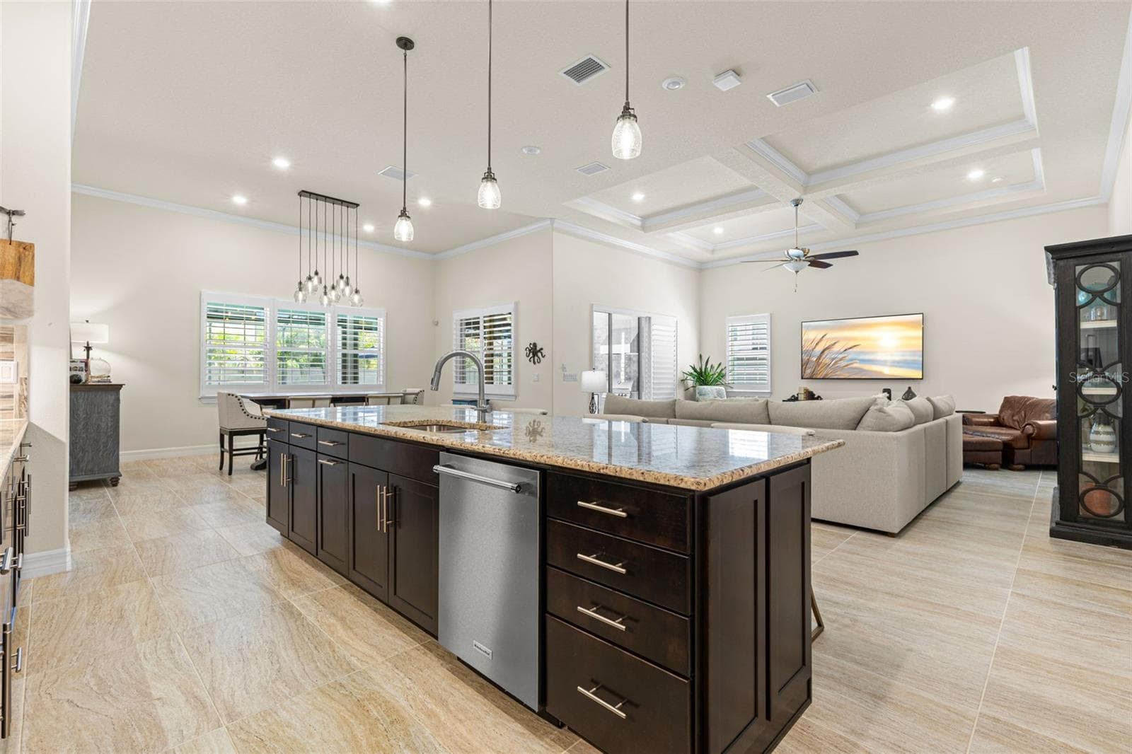 The oversized island earns its place at the center of the home, combining generous prep space, a double sink, dishwasher, deep drawers, additional cabinetry, and casual seating. From here, the kitchen opens effortlessly to both the dining area and great room, creating one expansive space for cooking, gathering, and entertaining. - 1528 FOREST GLEN CT, PALM HARBOR