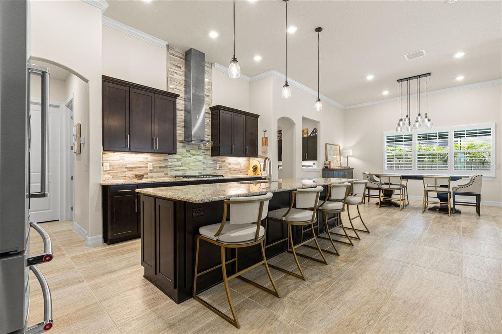 Just beyond the island, the dining area feels like a natural extension of the kitchen, with plenty of room for a generous table, plantation shutters filtering the light, and contemporary lighting defining the space without interrupting the open flow. - 1528 FOREST GLEN CT, PALM HARBOR