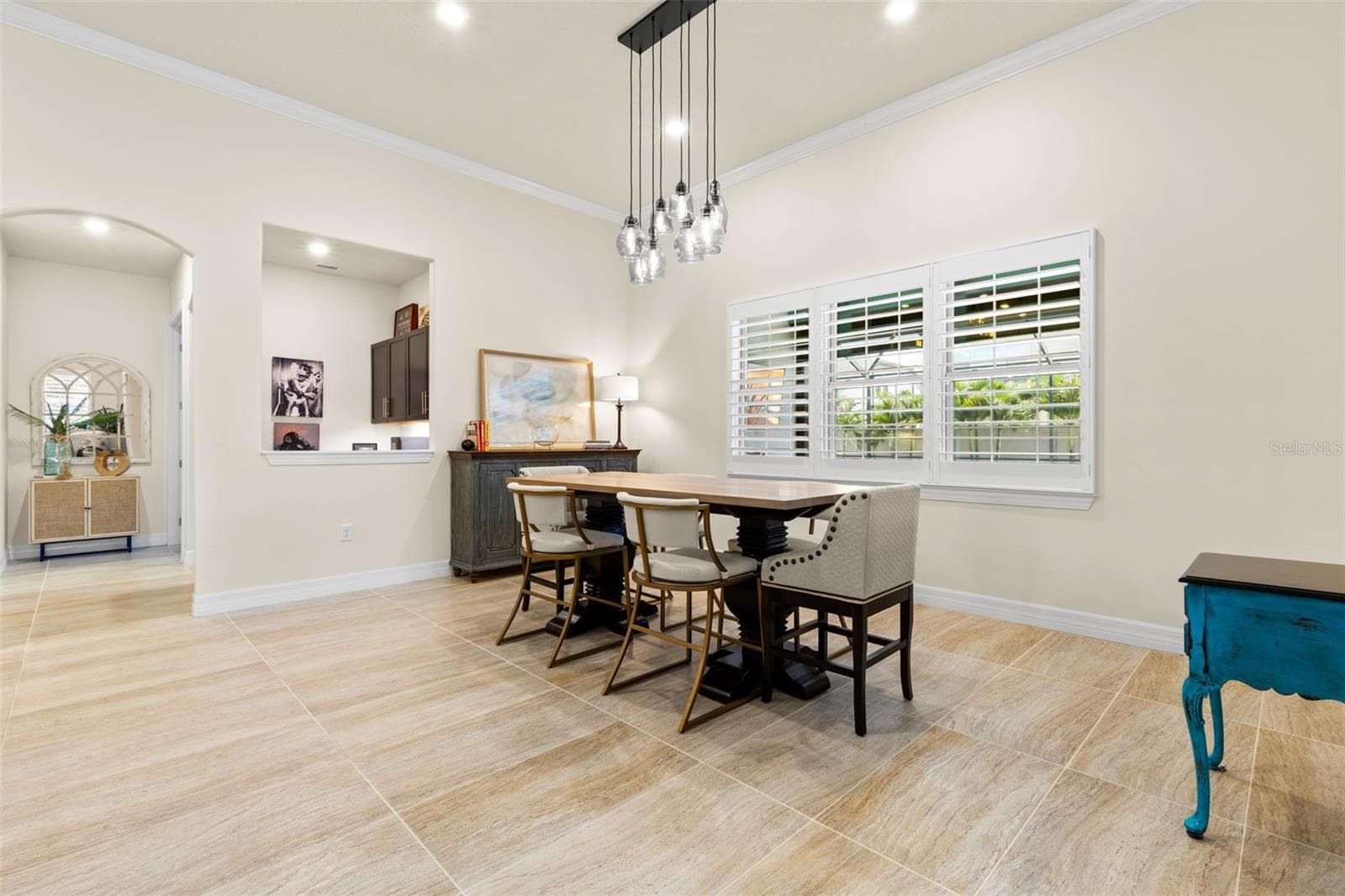 The dining area feels open and gracious, with oversized tile flooring, crown molding, plantation shutters and a striking clustered-glass chandelier overhead. - 1528 FOREST GLEN CT, PALM HARBOR