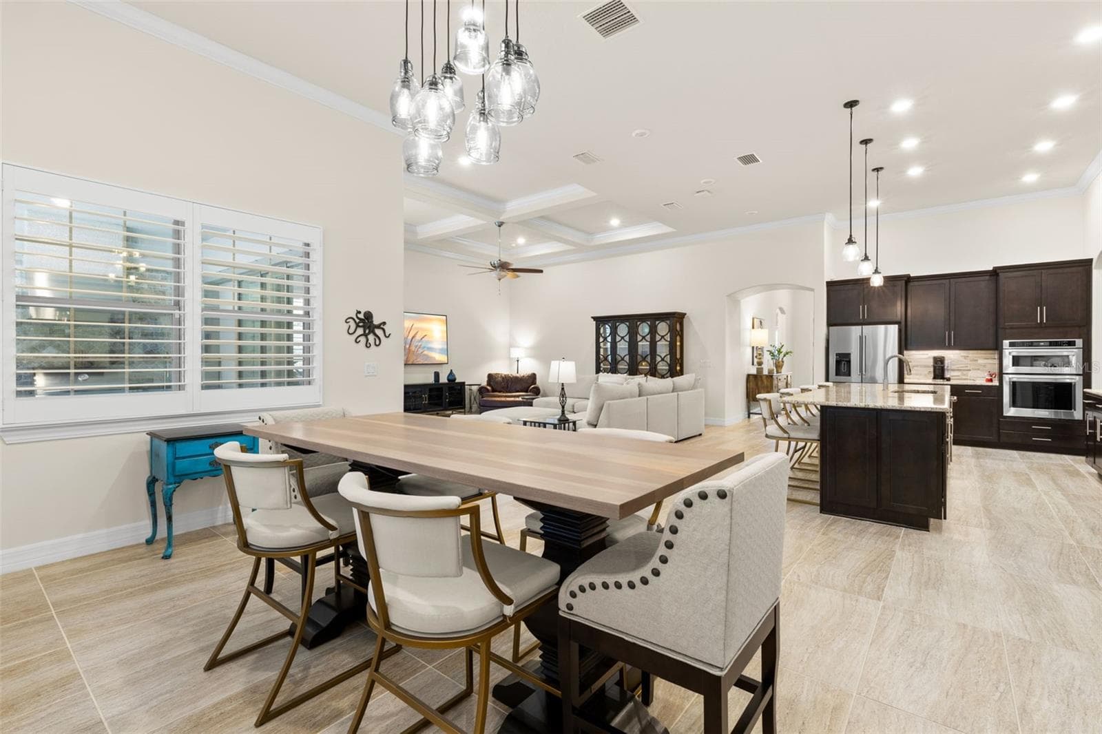 The dining area brings another layer of personality to the open floor plan, with a statement light fixture overhead, plantation shutters along the windows, and plenty of room for a substantial table. Positioned between the kitchen and great room, it keeps meals, conversation, and everyday living all comfortably connected. - 1528 FOREST GLEN CT, PALM HARBOR