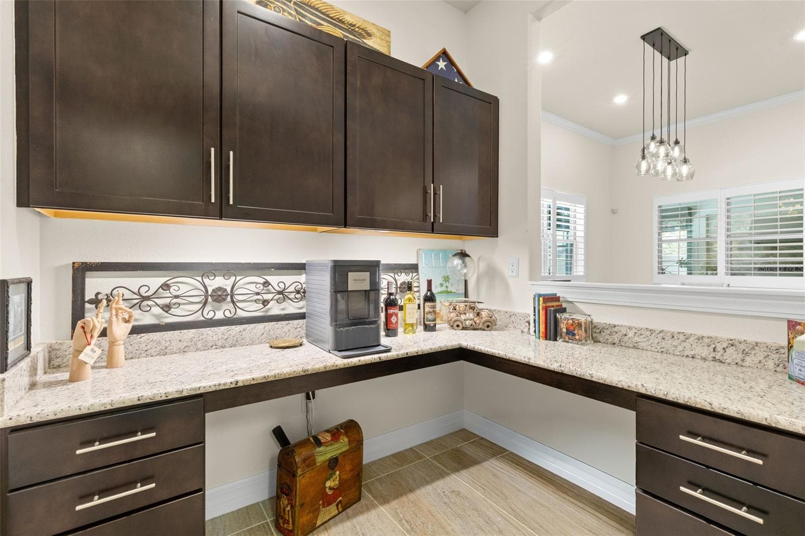 Just off the kitchen, a beautifully finished butler’s pantry-style workspace adds another layer of function, with granite counters, abundant cabinetry and a pass-through to the dining area. Use it as a coffee or wine bar, serving station, home office — or a little of each. - 1528 FOREST GLEN CT, PALM HARBOR