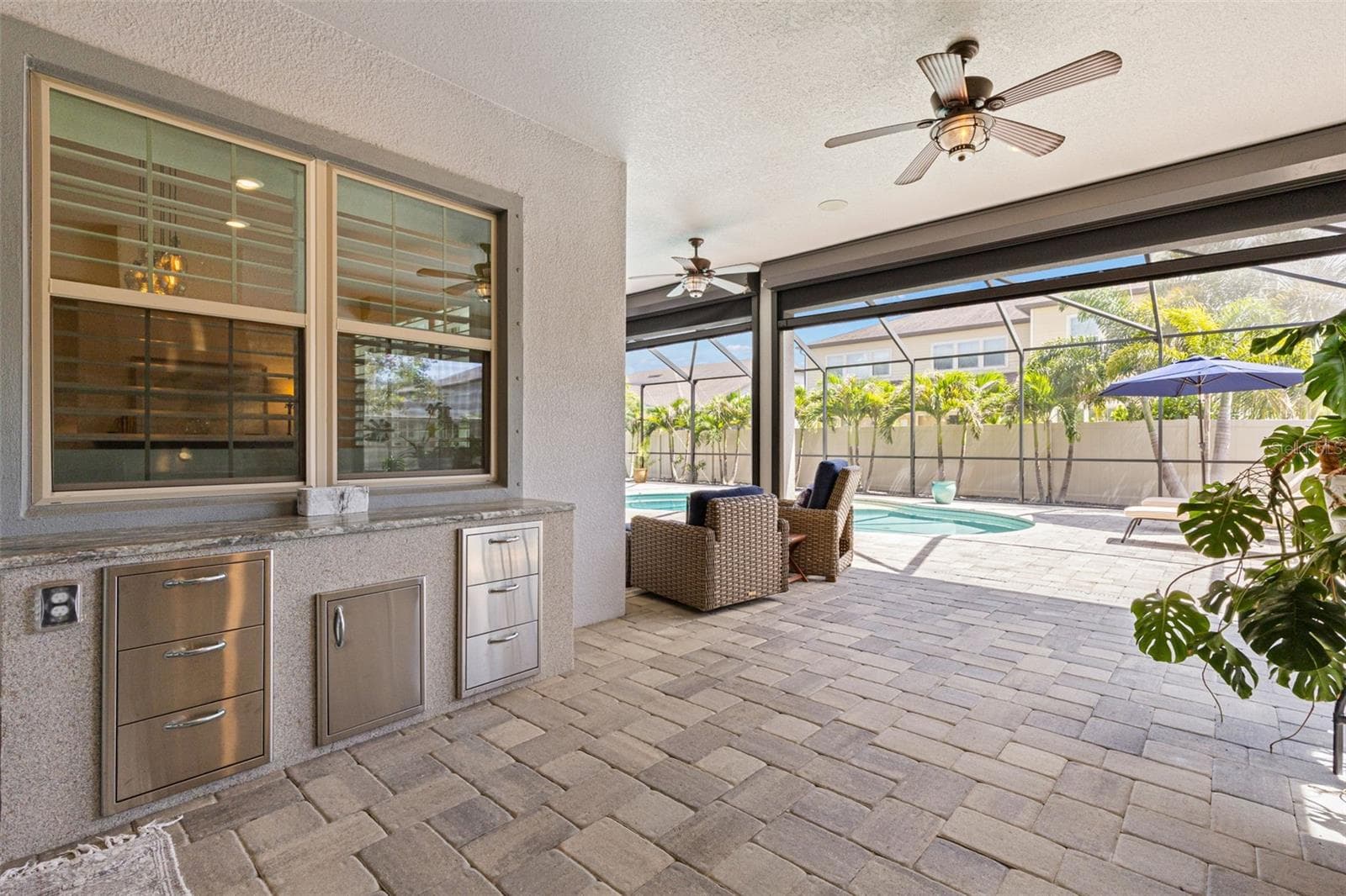 With ceiling fans overhead, generous covered space for dining or conversation, and the pool just beyond, the lanai feels like a true extension of the home rather than simply an outdoor add-on. Built-in storage along the serving counter keeps entertaining essentials close at hand. - 1528 FOREST GLEN CT, PALM HARBOR