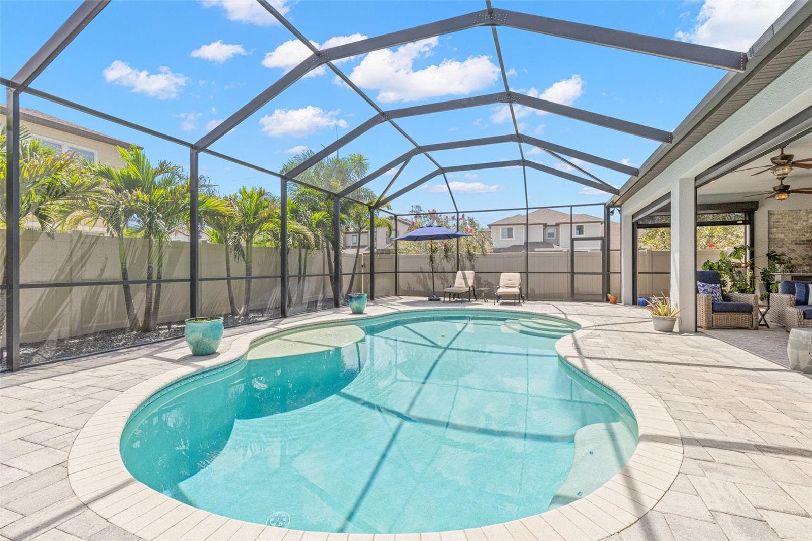 At the center of the outdoor living space, the freeform pool invites long afternoons in the sun, with wide entry steps, a shallow sun shelf and a generous brick-paver deck for lounging nearby. The covered lanai remains just steps away, creating an easy rhythm between sunshine, shade and the water. - 1528 FOREST GLEN CT, PALM HARBOR