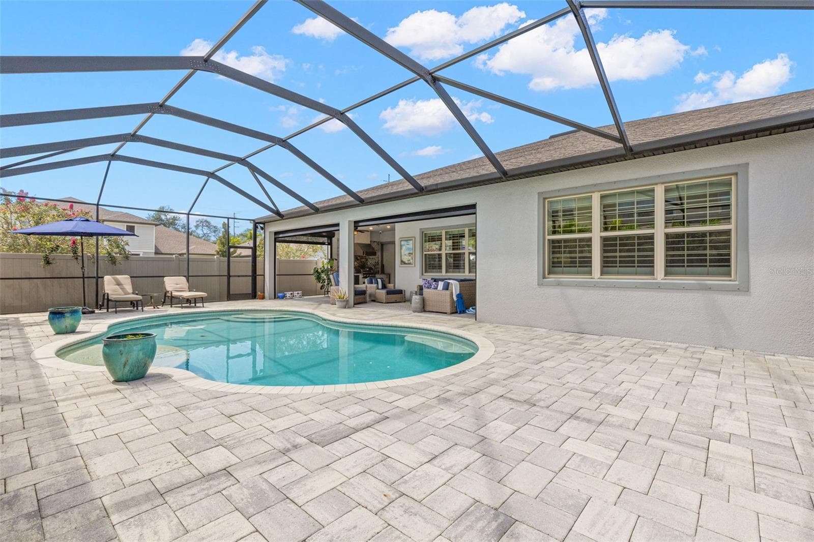 A broad brick-paver pool deck creates plenty of room to stretch out around the water, with space for loungers, conversation areas, and sunny afternoons by the pool. The covered lanai sits just steps away, adding shade and an easy transition back to the home. - 1528 FOREST GLEN CT, PALM HARBOR