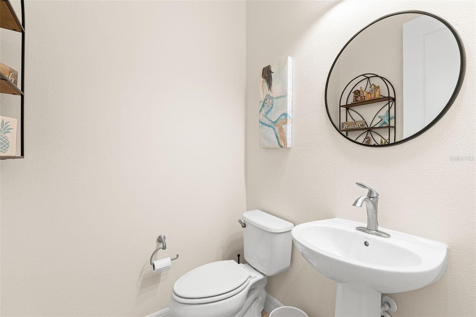 Conveniently positioned near the main living areas, the powder room offers a pedestal sink, contemporary faucet, round mirror and neutral finishes for a clean, polished look. - 1528 FOREST GLEN CT, PALM HARBOR