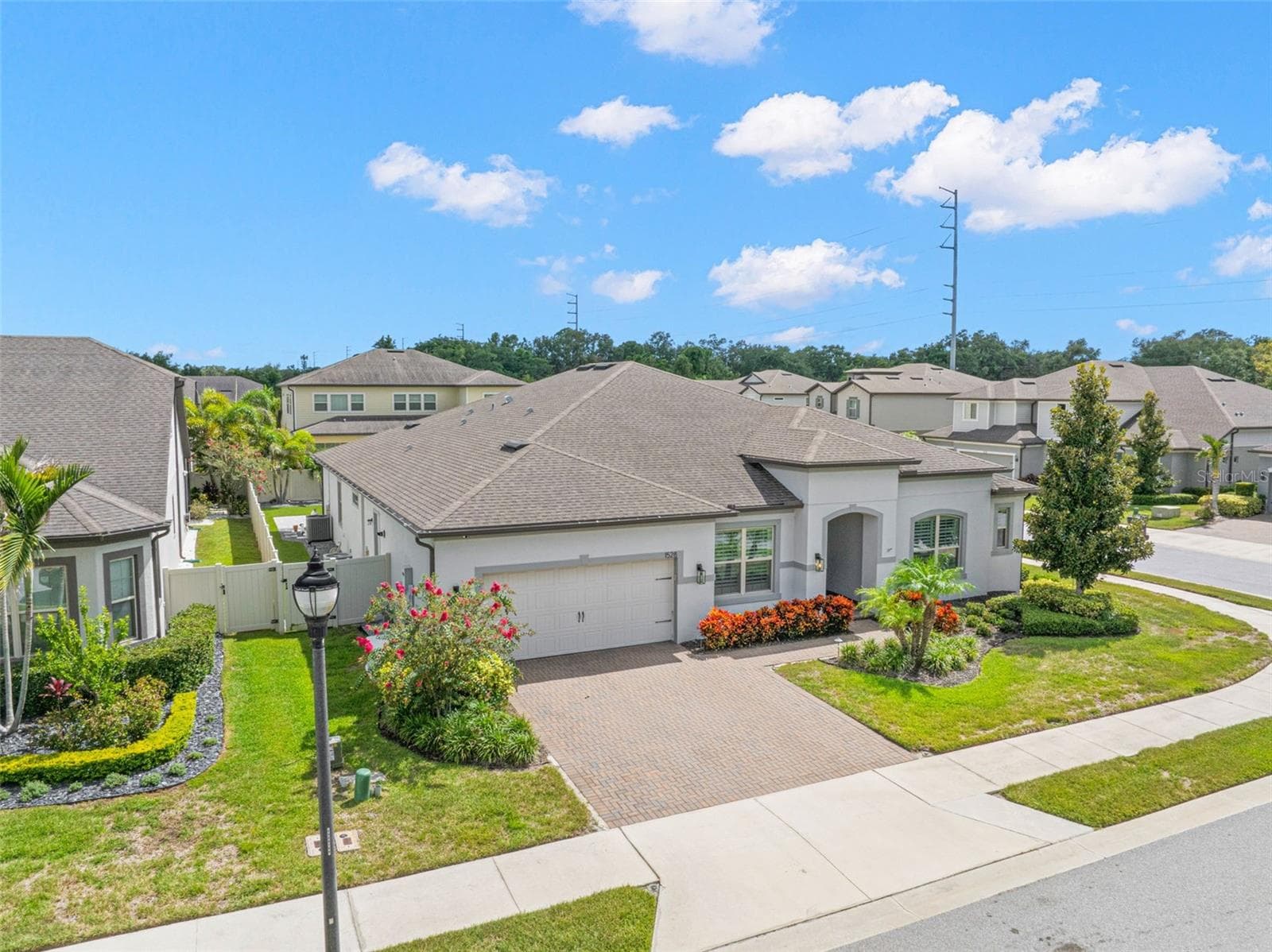 A charming neighborhood streetlamp complements the home’s polished curb appeal, while this elevated view reveals the fenced yard tucked behind the residence — adding privacy and another useful layer to the outdoor living space. - 1528 FOREST GLEN CT, PALM HARBOR