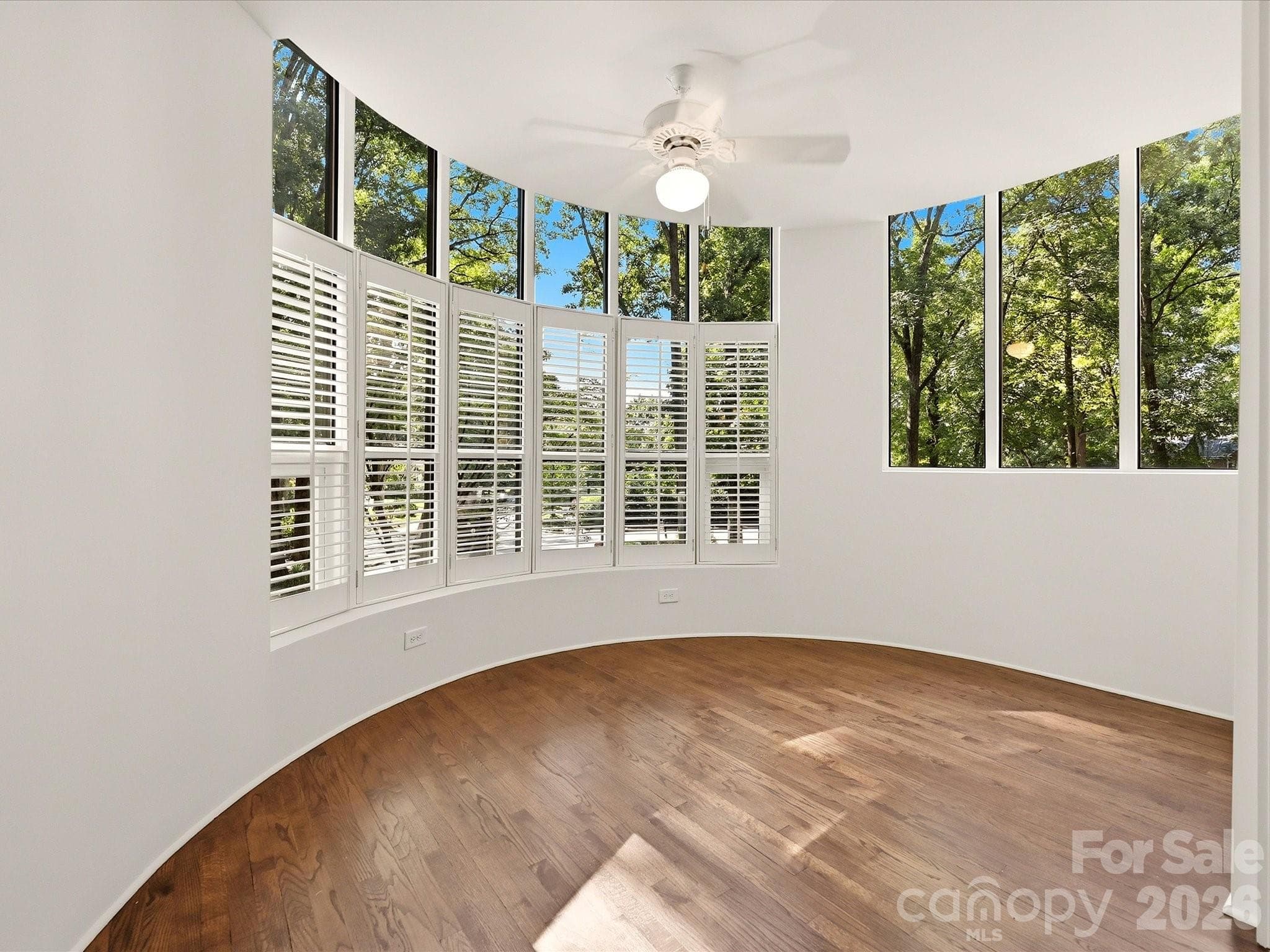 Sunroom with ceiling fan and a view of the mature trees - 806 Cherokee Road, Charlotte