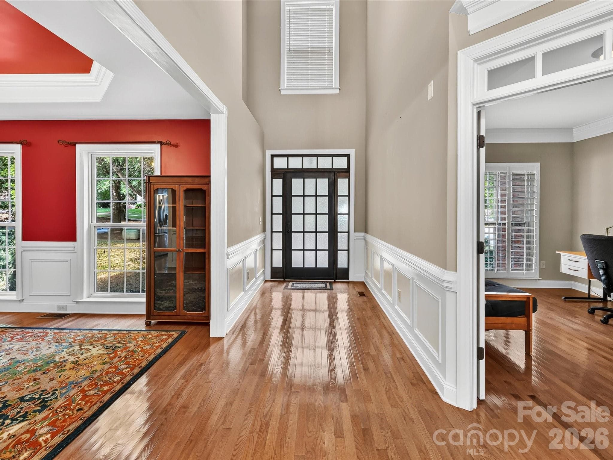 A bright two-story foyer with hardwood floors, detailed millwork, and abundant natural light welcomes you inside. - 11203 Warfield Avenue, Huntersville