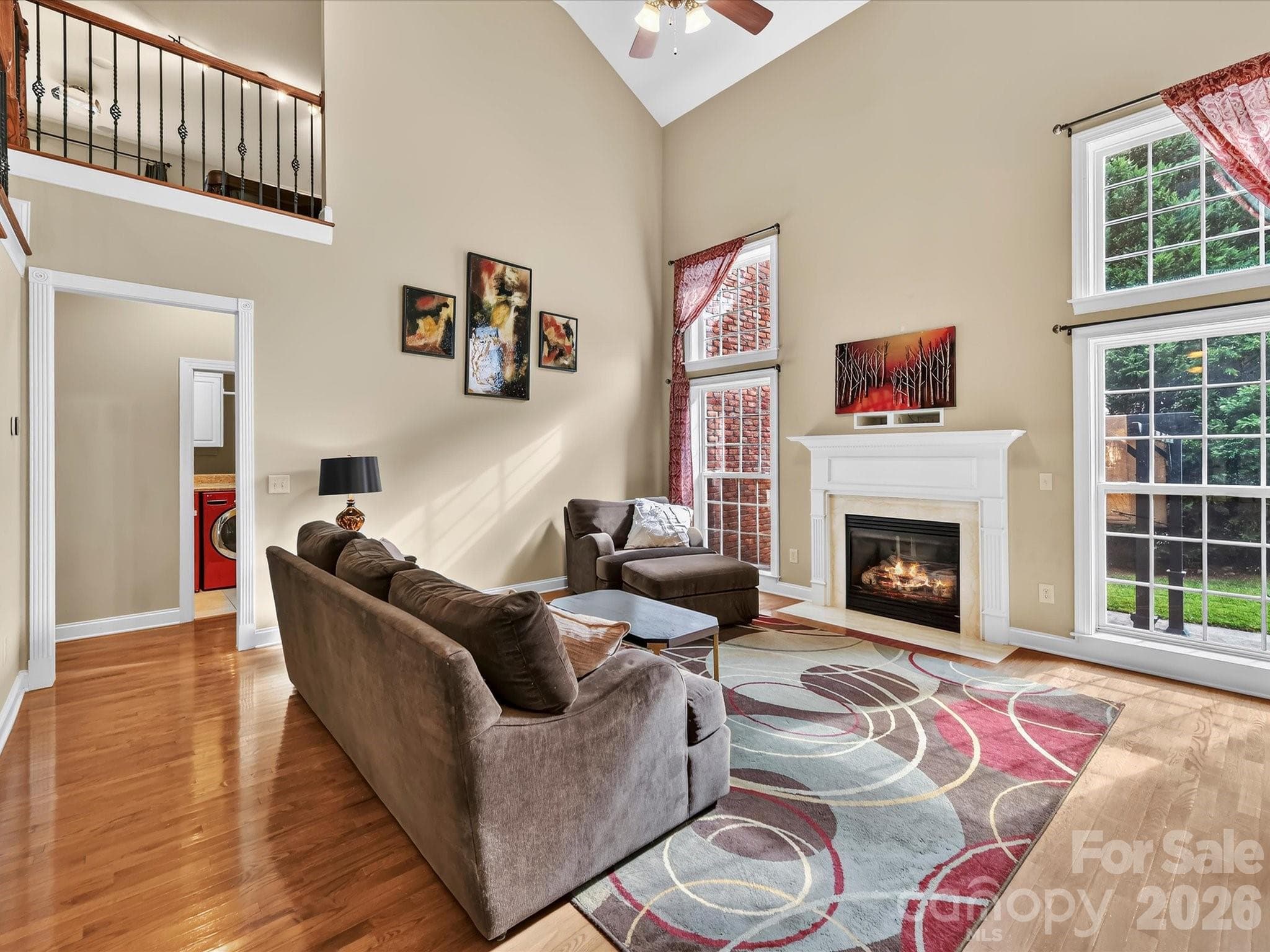 Soaring ceilings, expansive windows, and an open staircase create a bright and impressive two-story living space. - 11203 Warfield Avenue, Huntersville