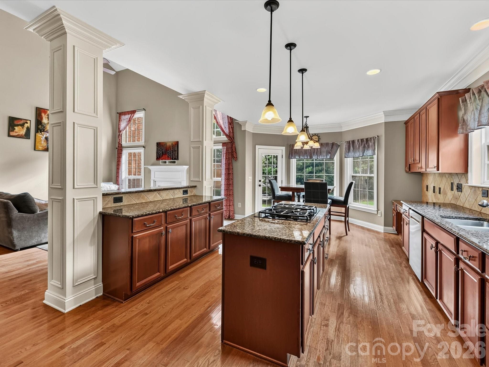 Generously sized kitchen showcasing granite countertops, stainless steel appliances, ample cabinetry, and a large center island with a built-in gas cooktop. - 11203 Warfield Avenue, Huntersville