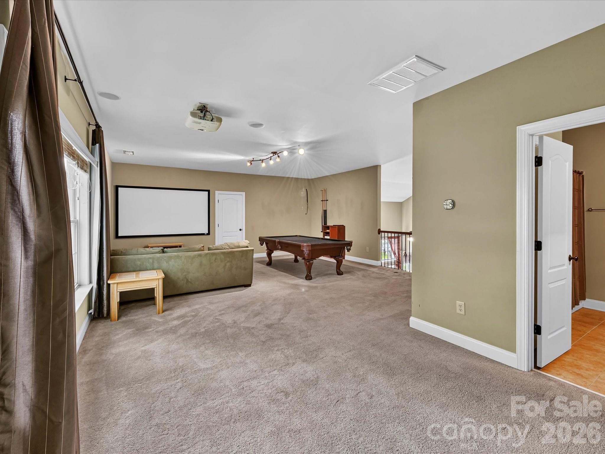 Oversized bonus room offers exceptional flexibility for a media room, game room, playroom, or additional lounge space. - 11203 Warfield Avenue, Huntersville
