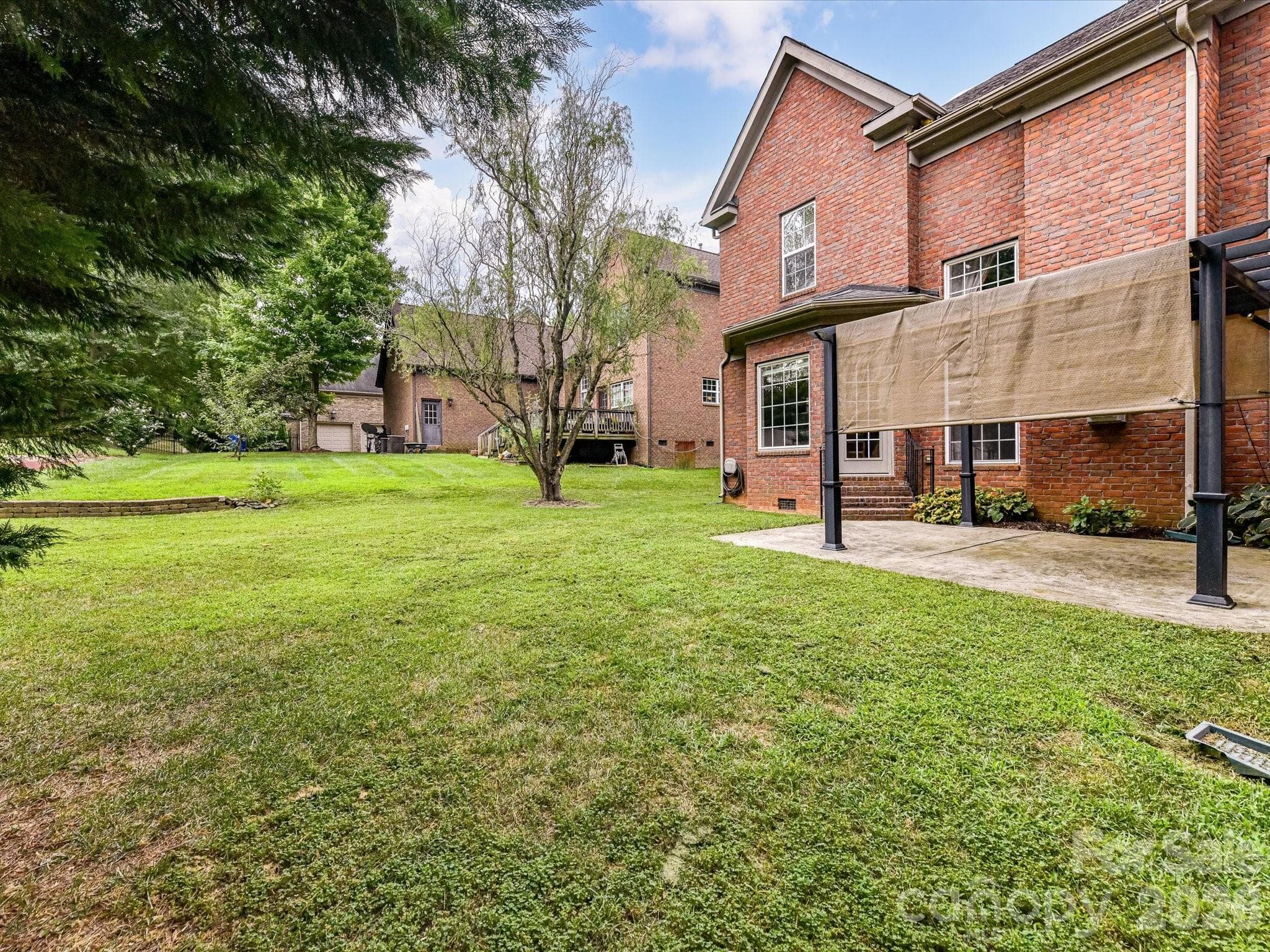 Spacious backyard with mature landscaping offers plenty of room for outdoor recreation, entertaining, or gardening. - 11203 Warfield Avenue, Huntersville
