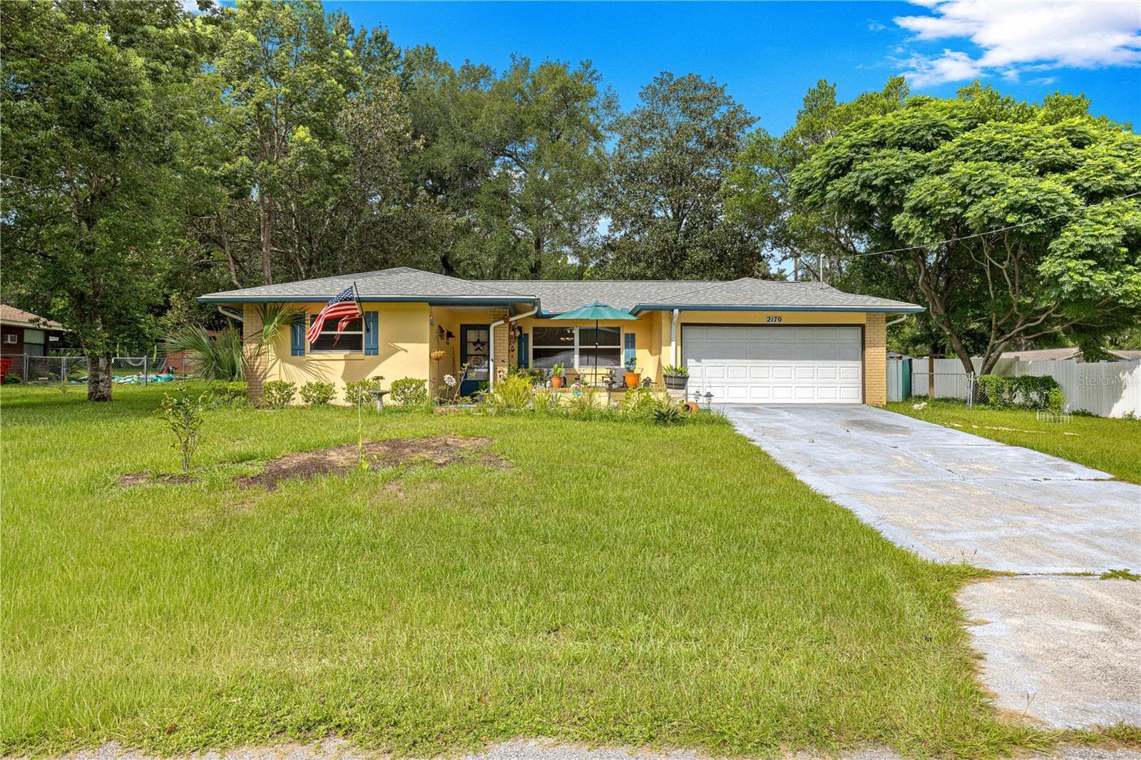 Front lawn and paved driveway leading to the attached two-car garage. - 2170 W DORAL CT, CITRUS SPRINGS