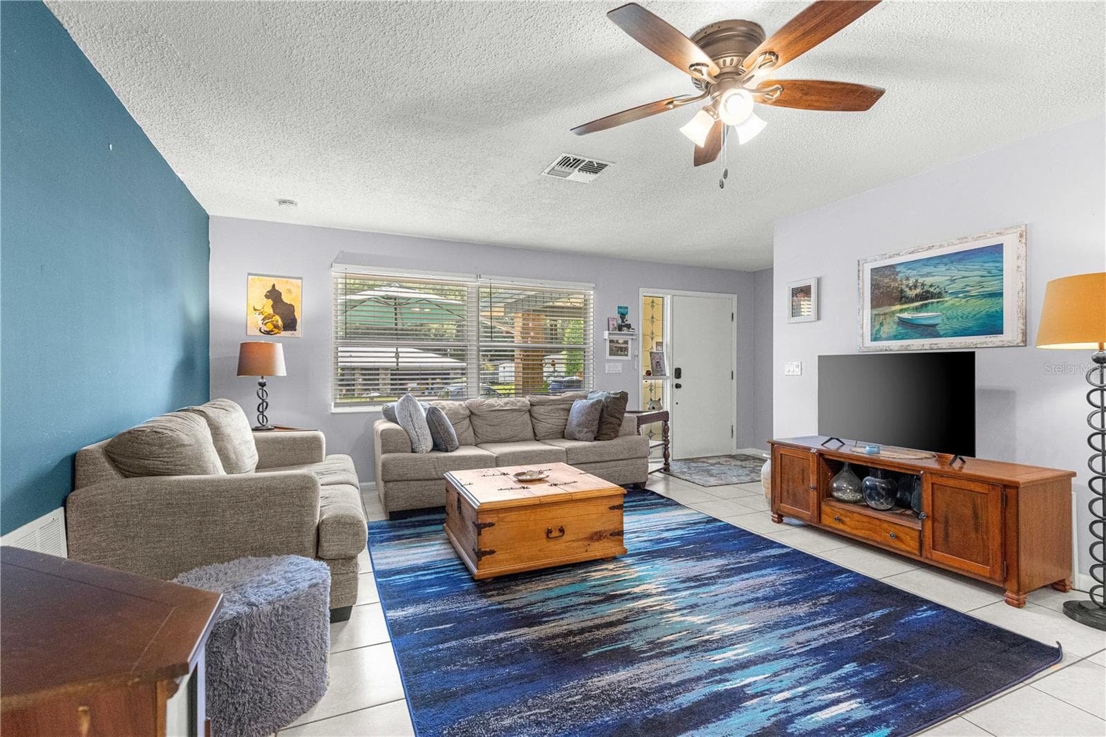 Living room with a large front window and space for a seating arrangement. - 2170 W DORAL CT, CITRUS SPRINGS