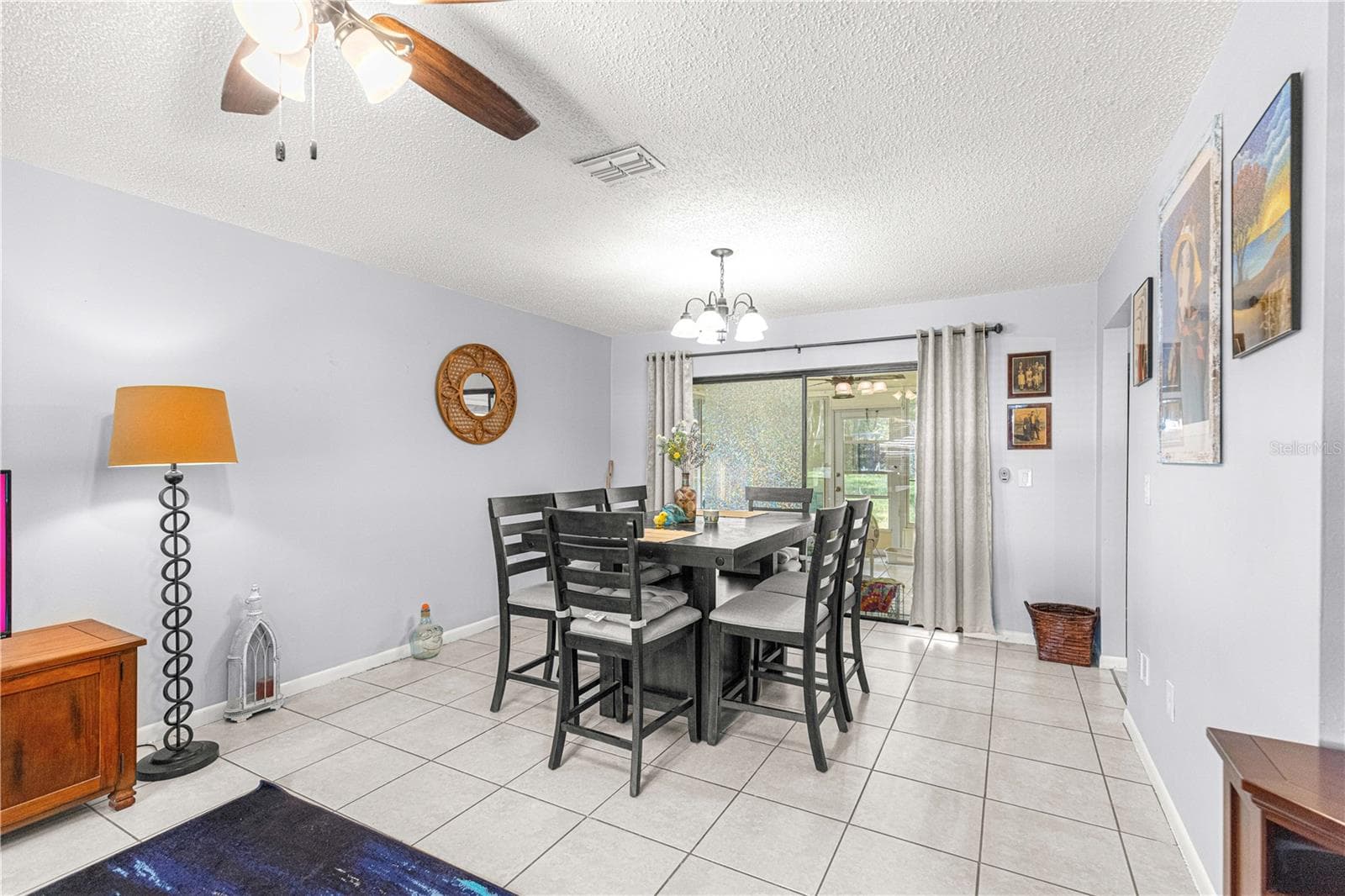 Dining area beside the living room, with tile flooring and a ceiling fan. - 2170 W DORAL CT, CITRUS SPRINGS