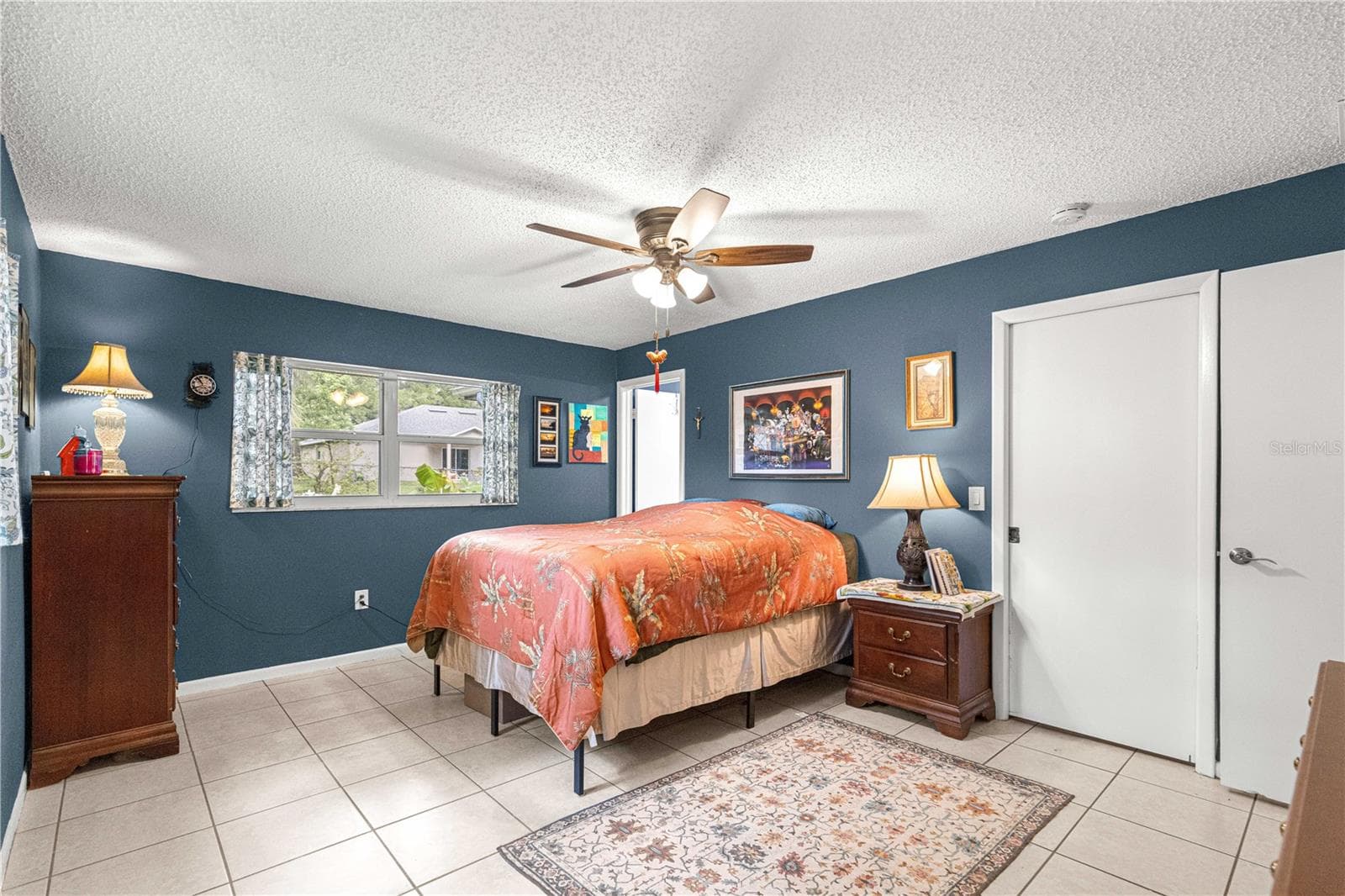 Primary bedroom with tile flooring, a ceiling fan and closet storage. - 2170 W DORAL CT, CITRUS SPRINGS