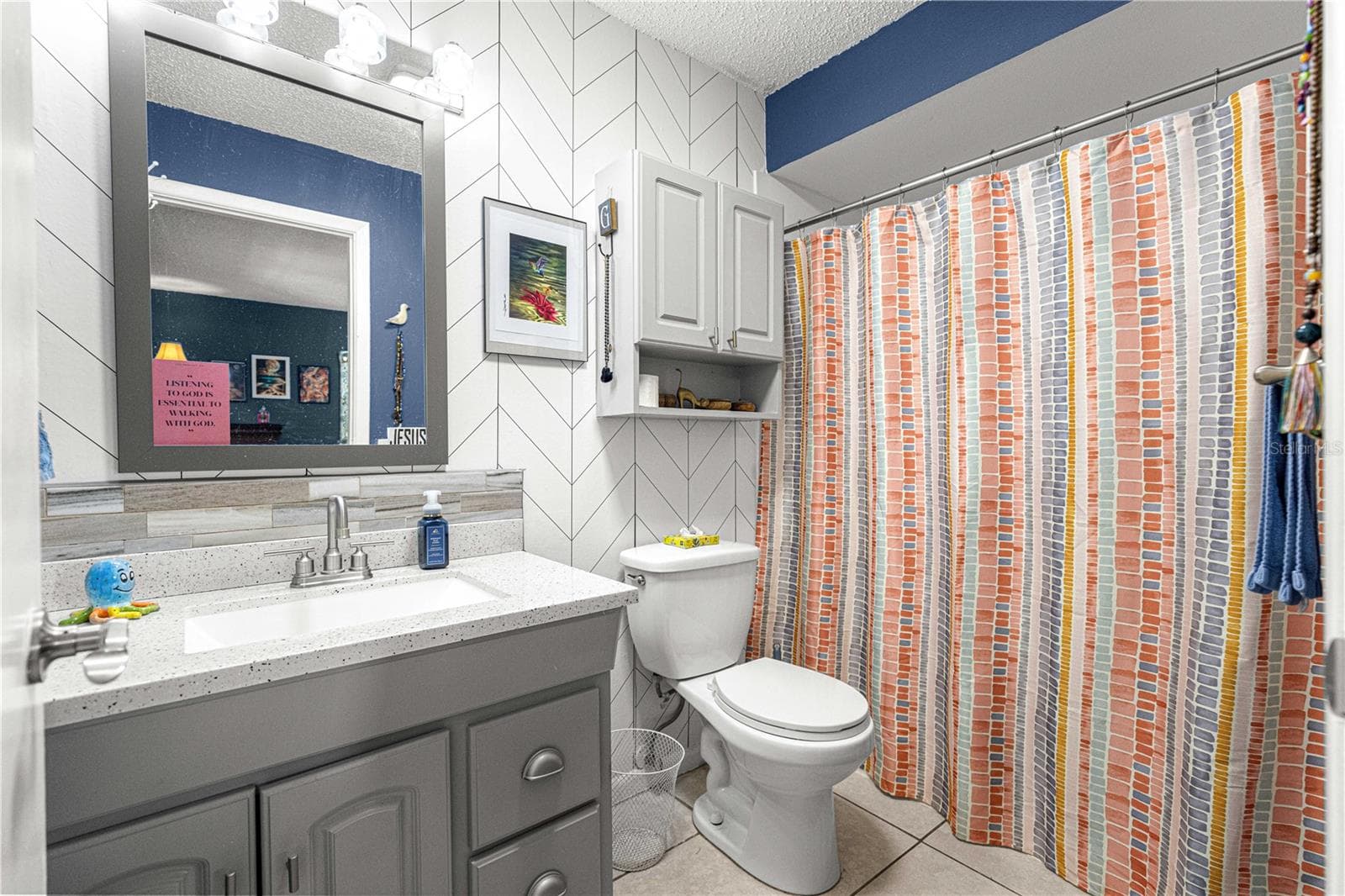 Primary bathroom with vanity storage and tiled finishes. - 2170 W DORAL CT, CITRUS SPRINGS