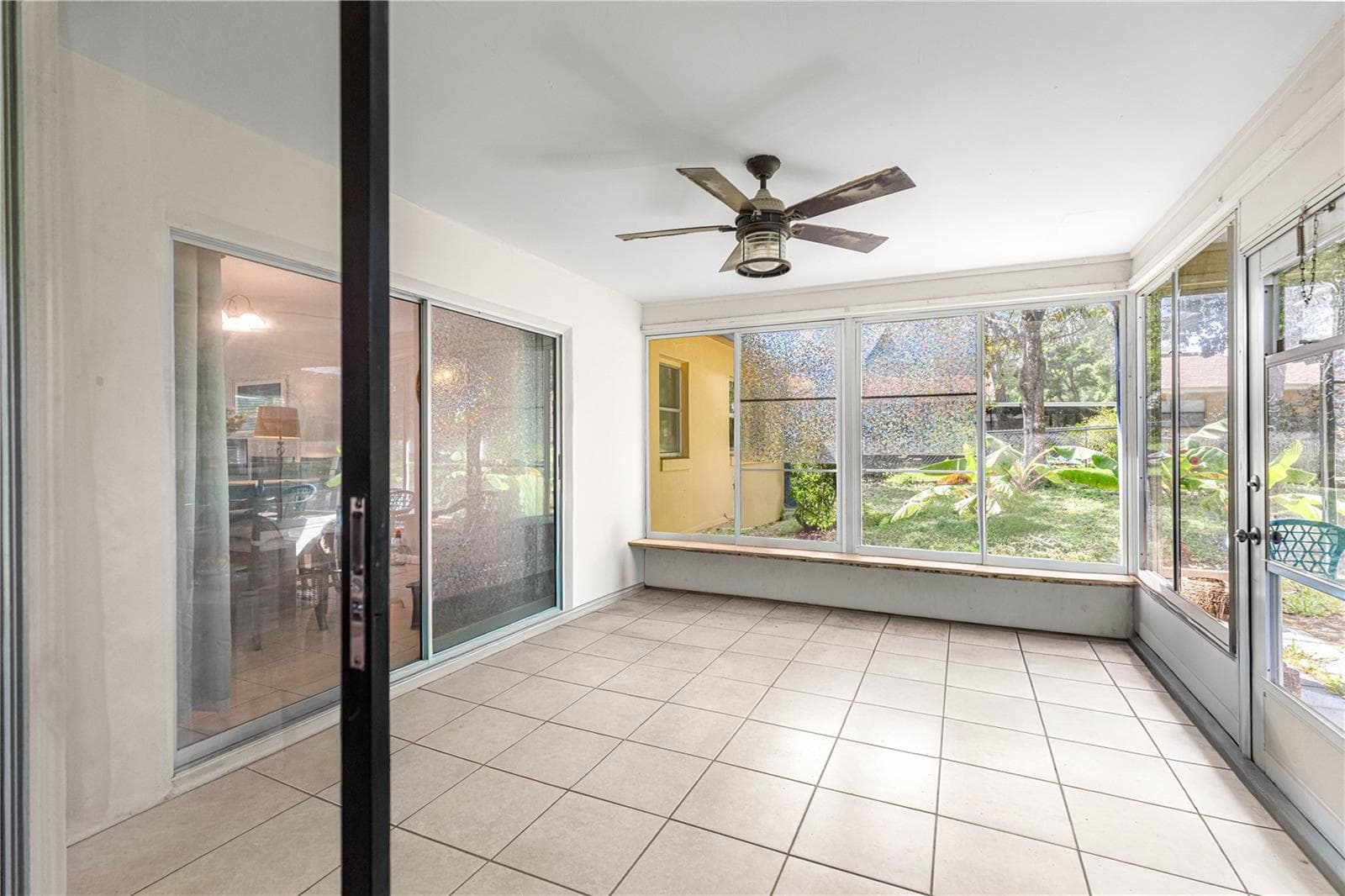 Enclosed rear porch with tile flooring, a ceiling fan and backyard views. - 2170 W DORAL CT, CITRUS SPRINGS
