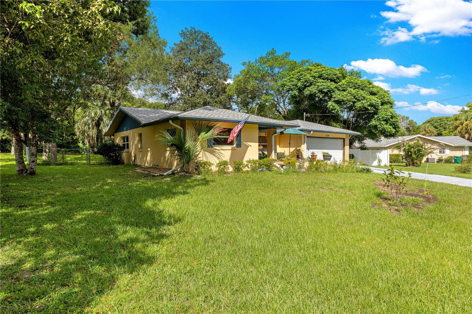 Front exterior and lawn framed by mature landscaping. - 2170 W DORAL CT, CITRUS SPRINGS