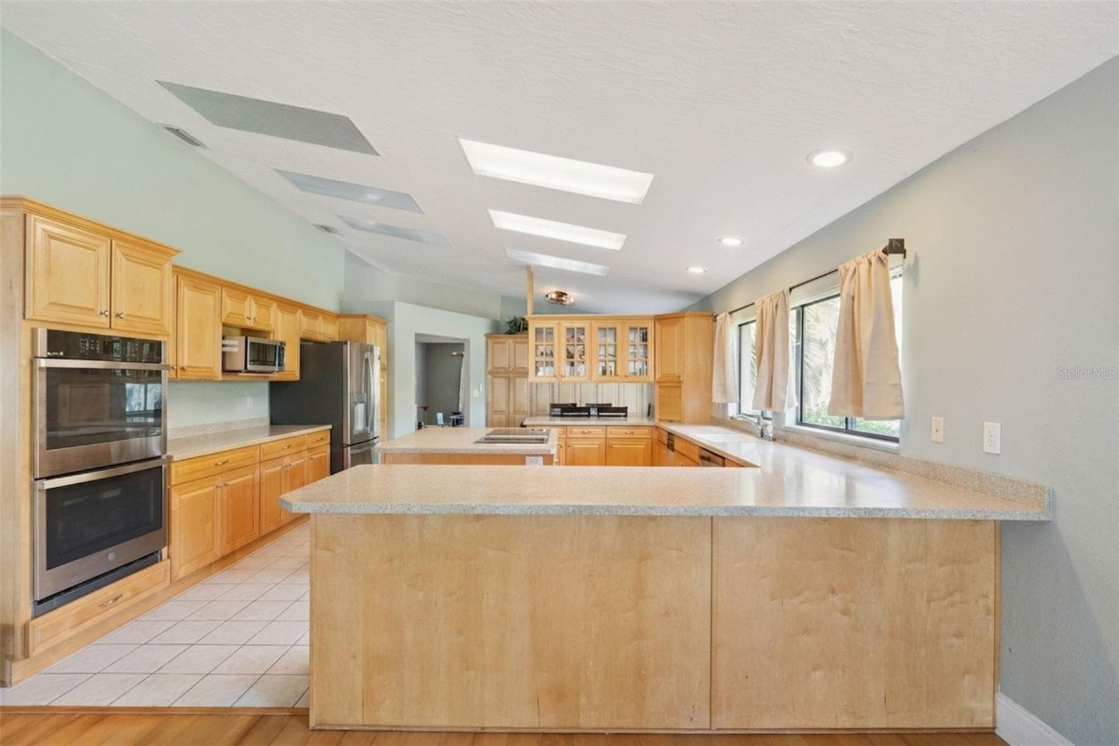 Enormous kitchen featuring double ovens, bar seating, abundant cabinetry and countertop space, and cooking island! - 25 LAKEWOOD CSWY, WINTER HAVEN
