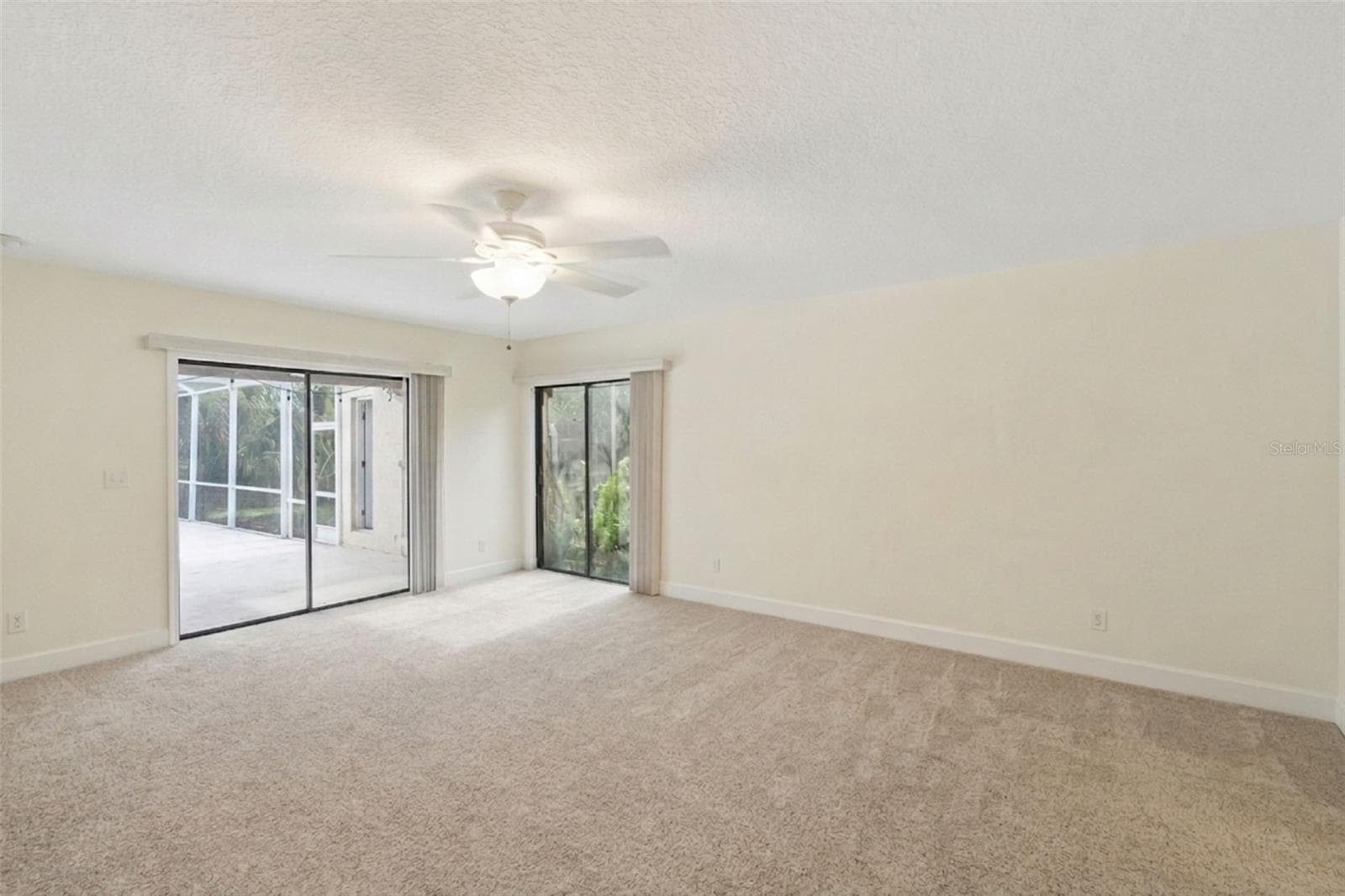 Primary Suite with double sliding glass doors and access to the pool/patio. - 25 LAKEWOOD CSWY, WINTER HAVEN