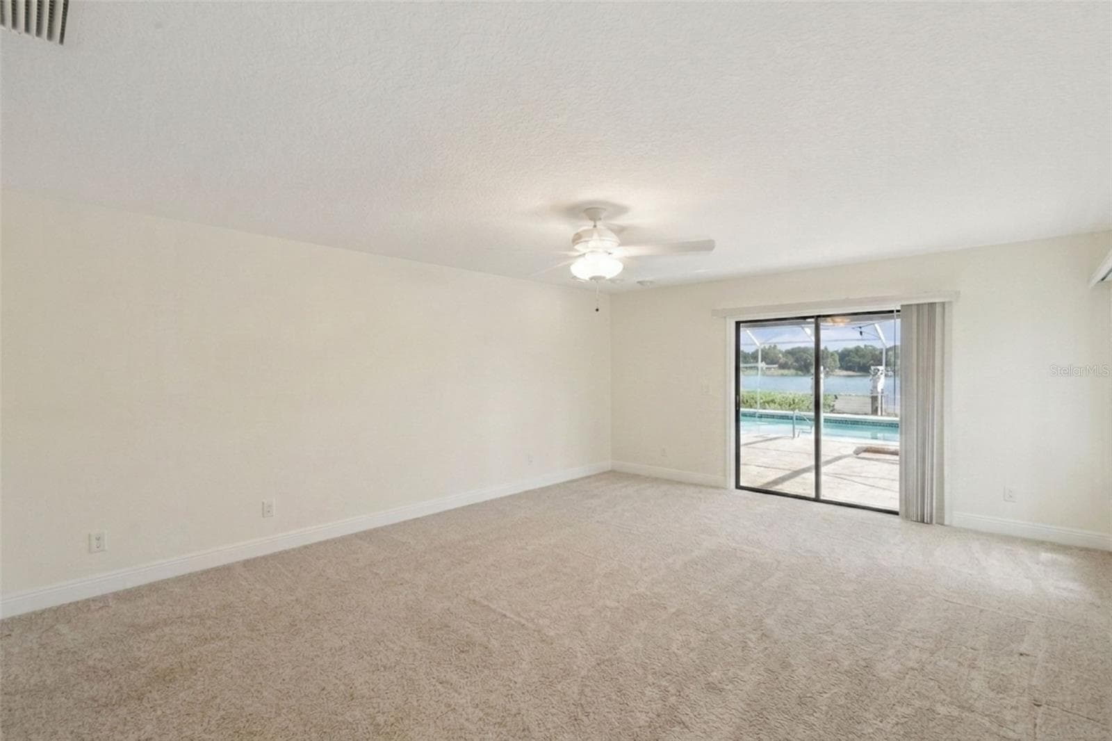Primary bedroom with views of the pool and Lake Link. - 25 LAKEWOOD CSWY, WINTER HAVEN