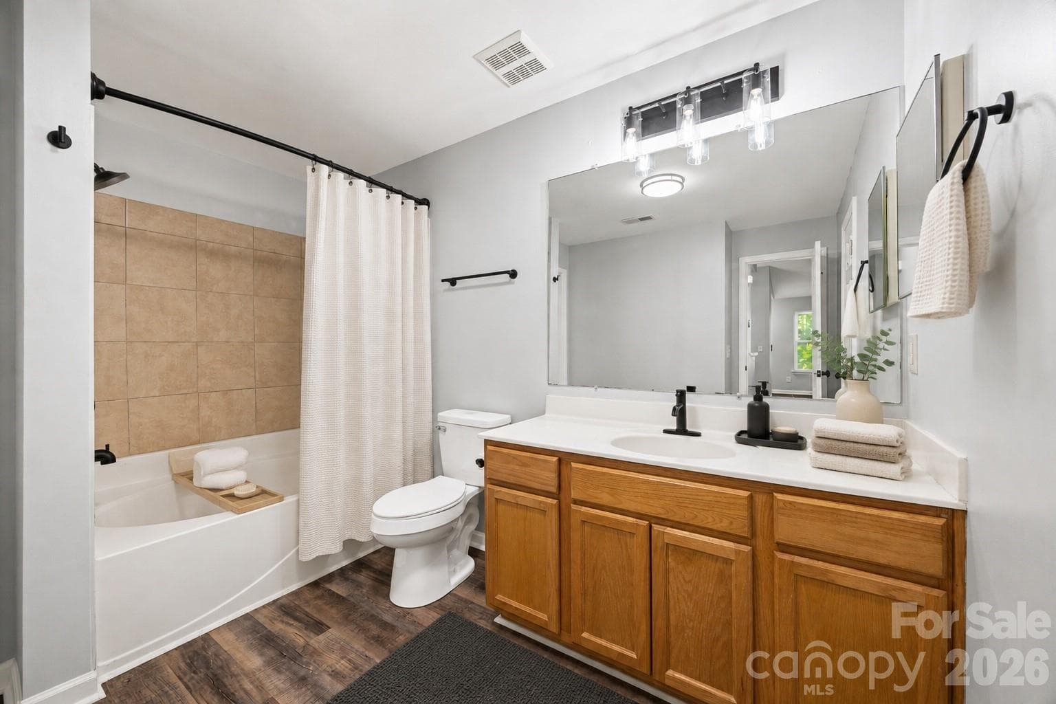 Bathroom with large vanity, new light fixture, new faucets and new toilet. Virtually Staged - 8119 Tremaine Court, Charlotte