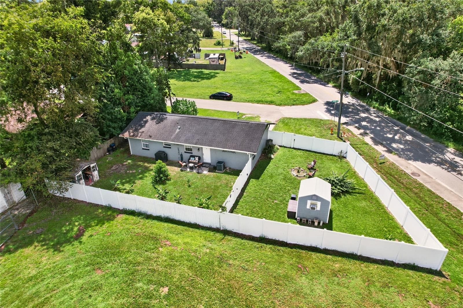 Aerial view closer in to the back yard with divided yard with new white vinyl fencing - 5203 SE 114TH ST, BELLEVIEW