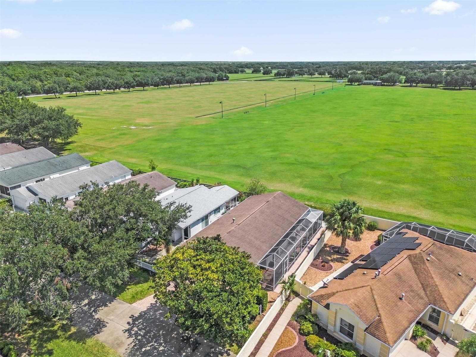 Drone view showcasing the home and the adjacent polo field. - 2801 BARBOZA DR, THE VILLAGES