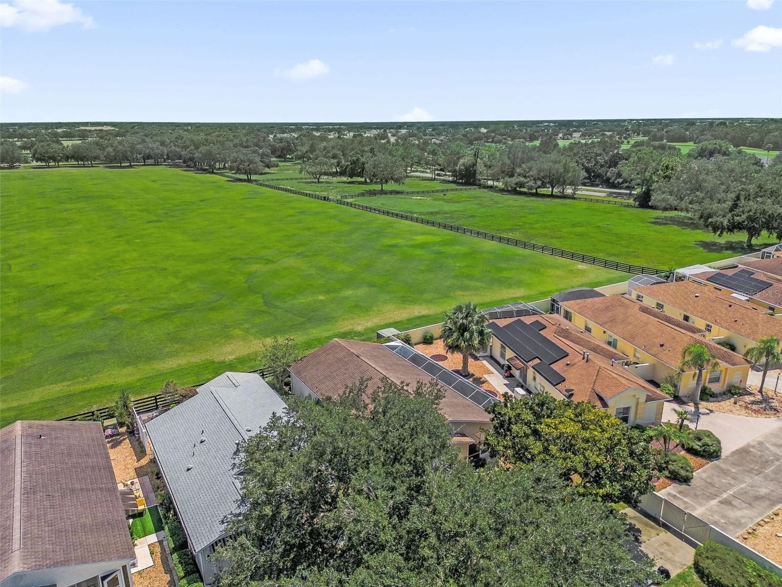 Drone view showcasing the home and the adjacent polo field. - 2801 BARBOZA DR, THE VILLAGES