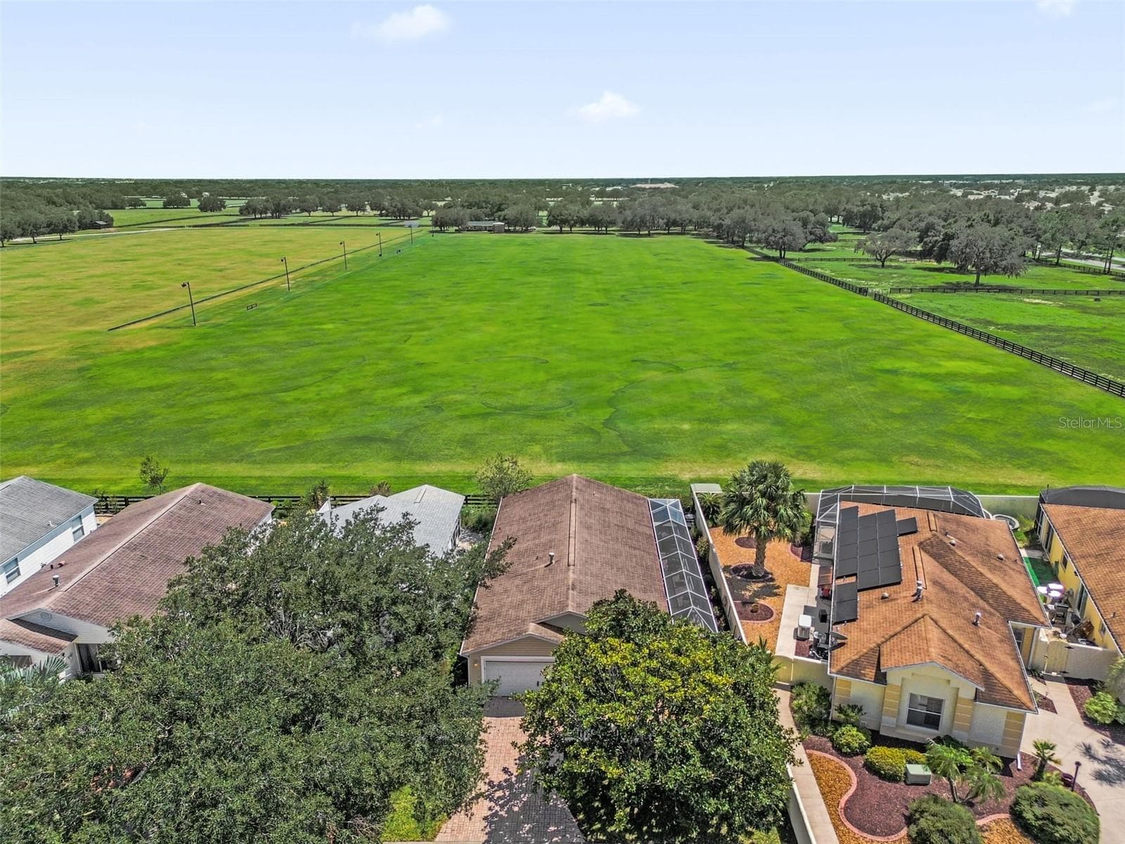 Drone view showcasing the home and the adjacent polo field. - 2801 BARBOZA DR, THE VILLAGES