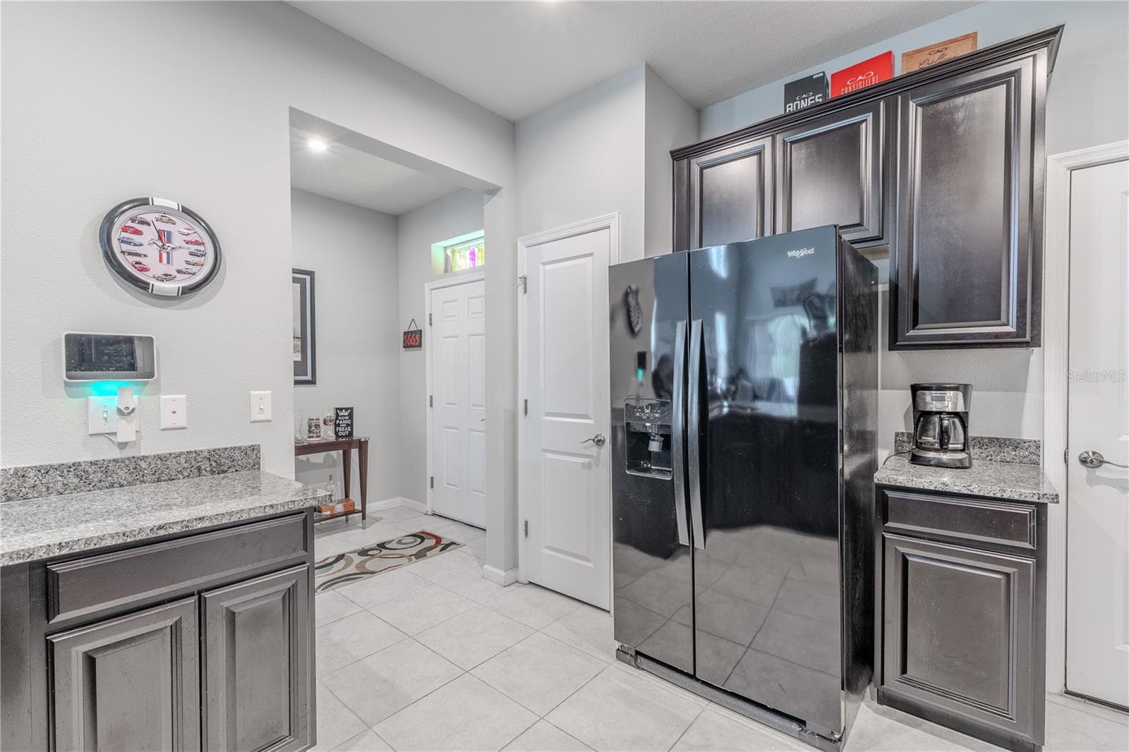The granite-topped peninsula wraps around the kitchen, adding storage and workspace while creating an easy connection to the adjoining living area. - 3029 JACOB CROSSING LN, HOLIDAY