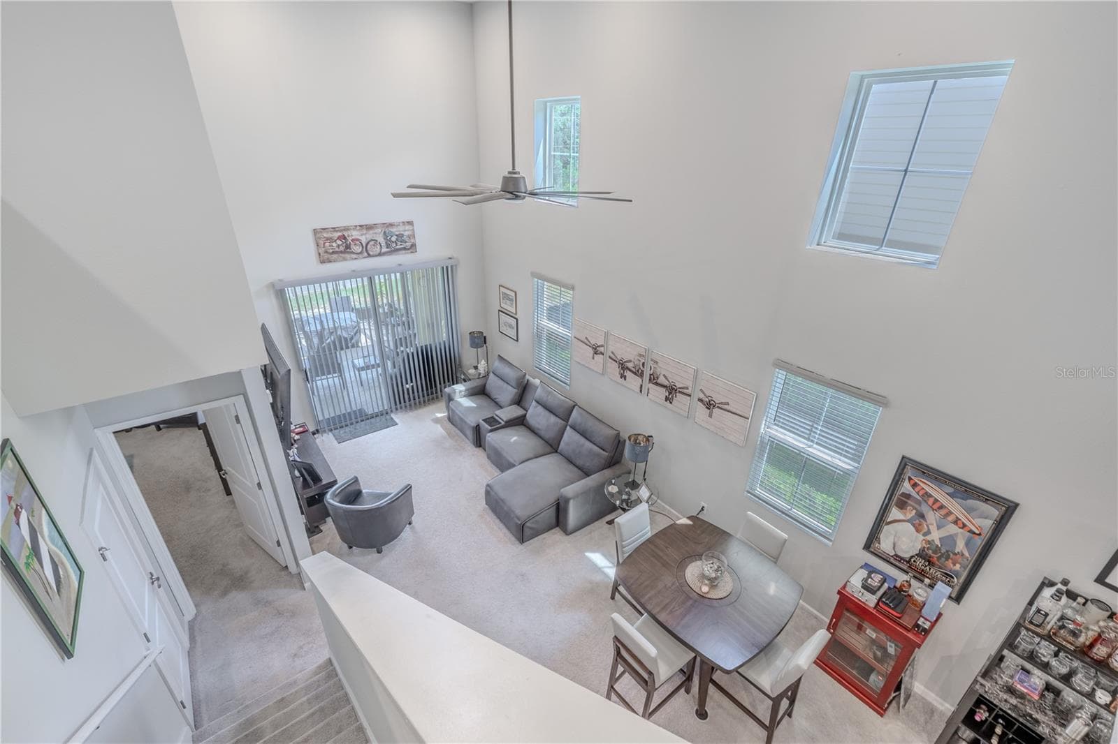 Soaring ceilings, abundant natural light and a soft neutral palette give the living room an airy, inviting presence, with sliding glass doors extending the space to the screened lanai. - 3029 JACOB CROSSING LN, HOLIDAY