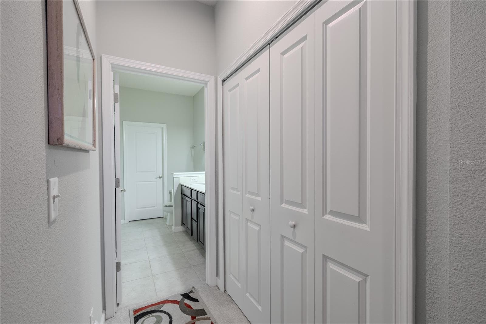 A full wall of closet storage is incorporated into the primary bedroom, with the ensuite bath positioned just beyond for convenient everyday flow. - 3029 JACOB CROSSING LN, HOLIDAY
