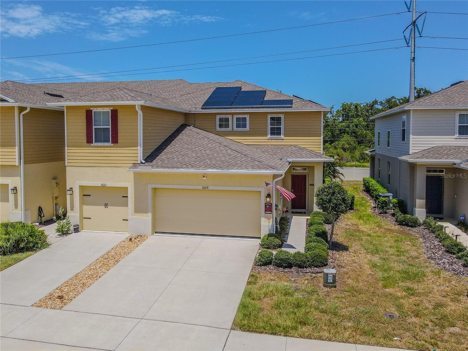 End-unit positioning, an attached 2-car garage, rooftop solar panels and a landscaped side entry give the home strong curb appeal, with added separation along the side creating a more open setting than many townhomes offer. - 3029 JACOB CROSSING LN, HOLIDAY